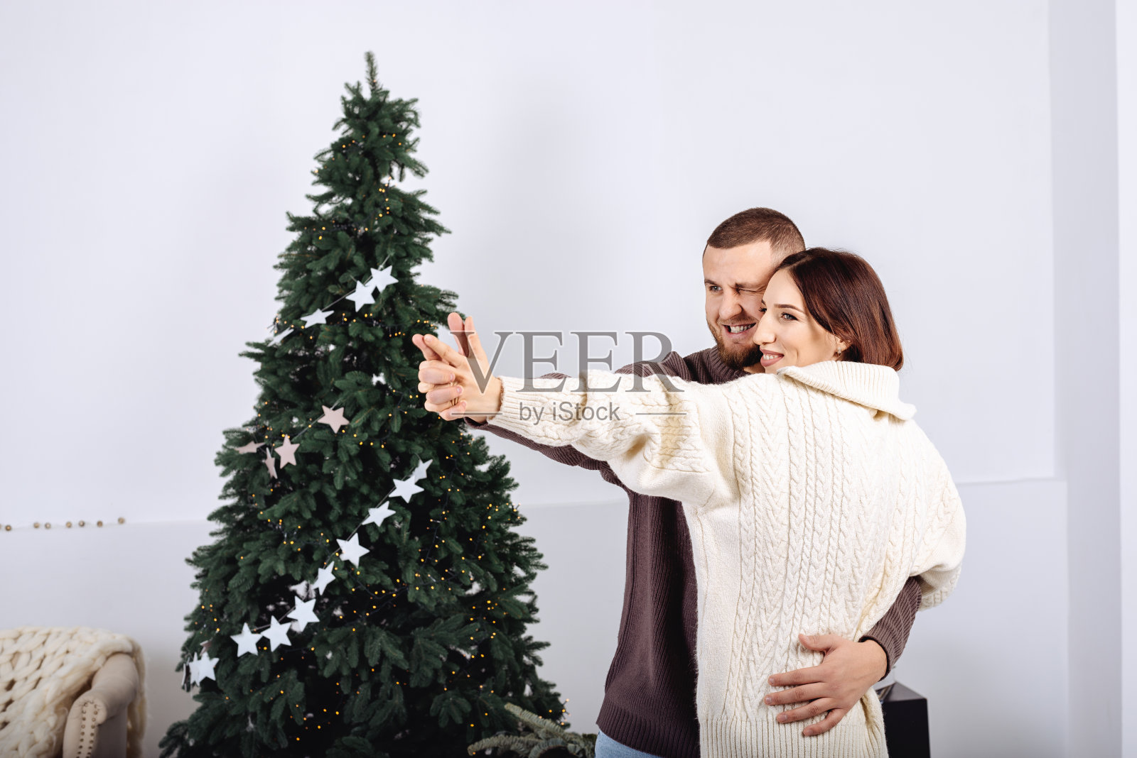 一对情侣在圣诞树前跳舞照片摄影图片