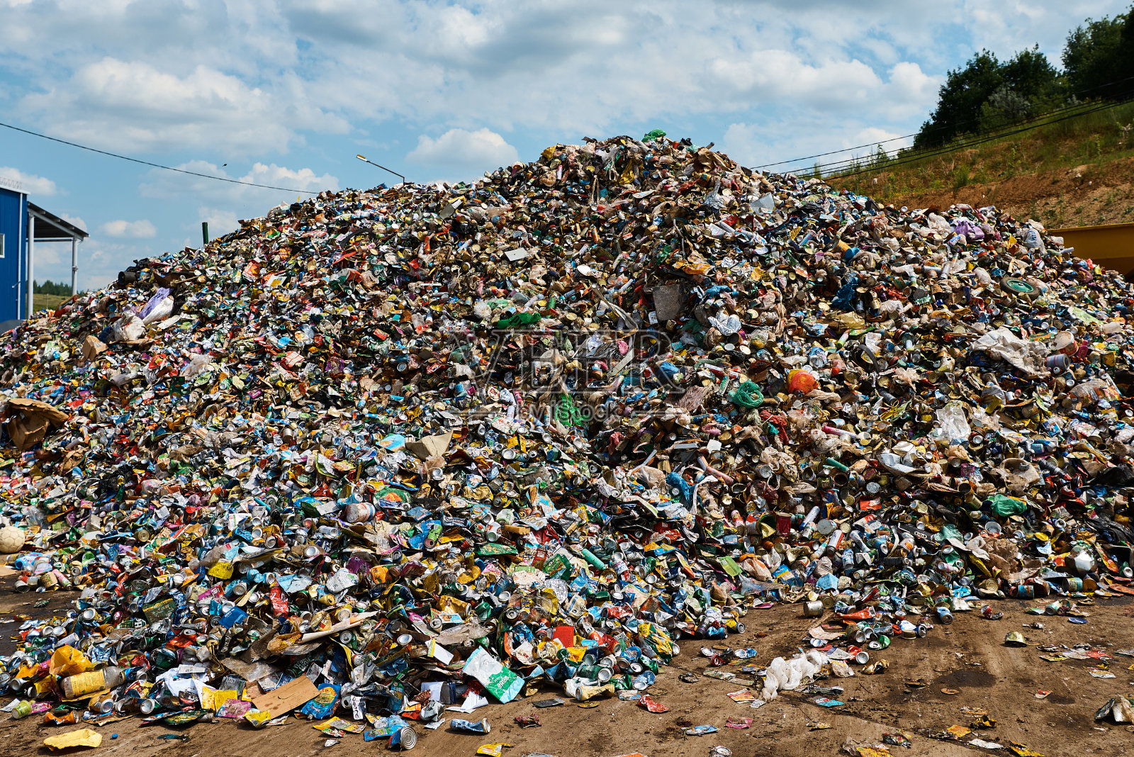 乌云密布的天空下，垃圾回收厂的巨大堆照片摄影图片