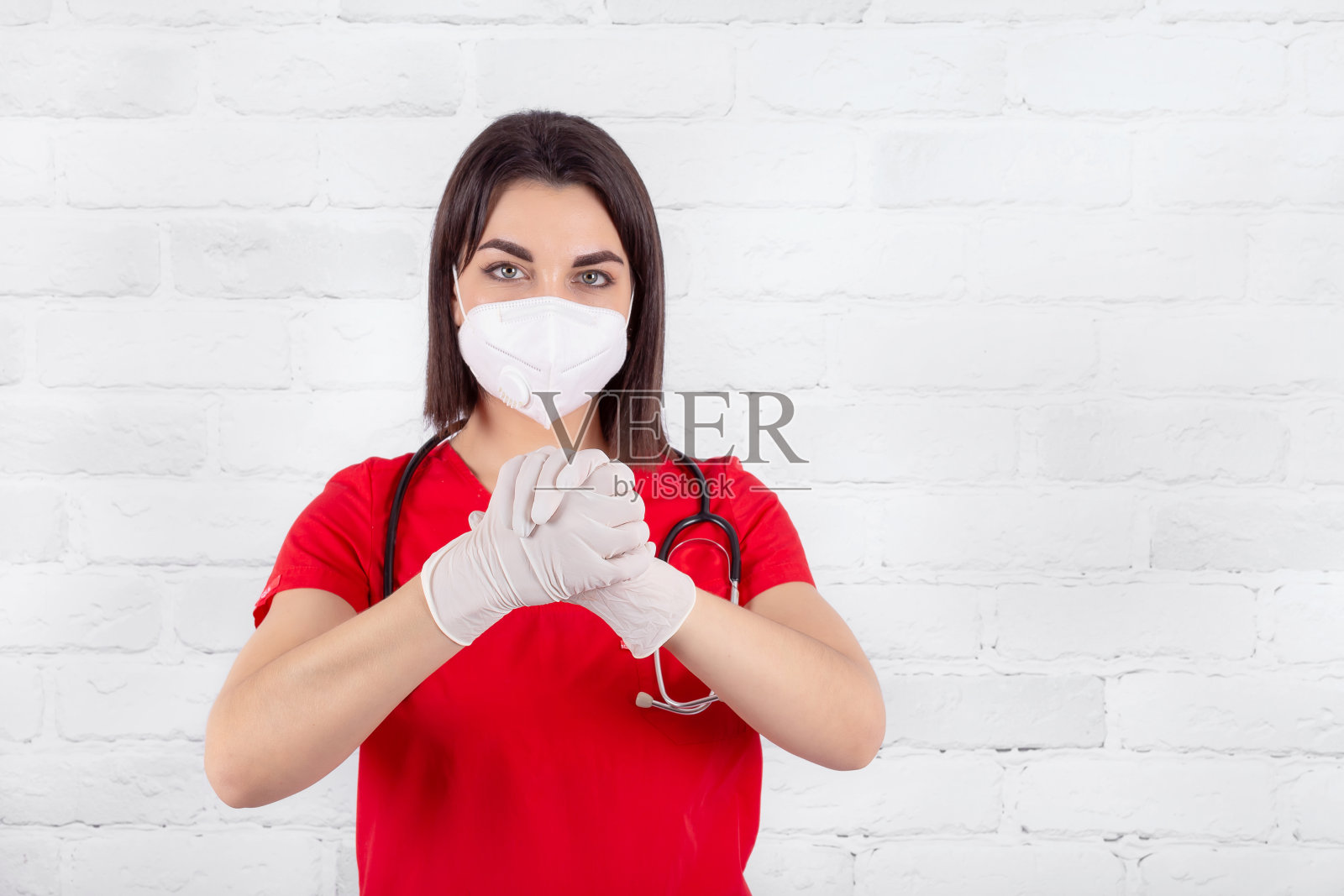 医生身着制服，戴着医用无菌手套，双手并举表示支持照片摄影图片