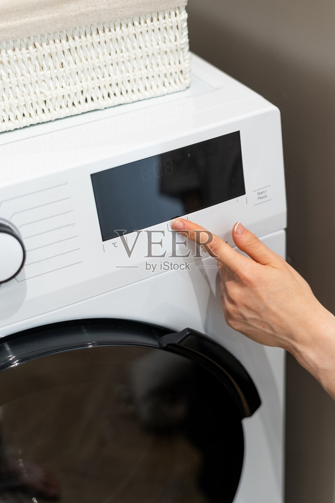 女人在洗衣服前按下洗衣机上的按钮照片摄影图片
