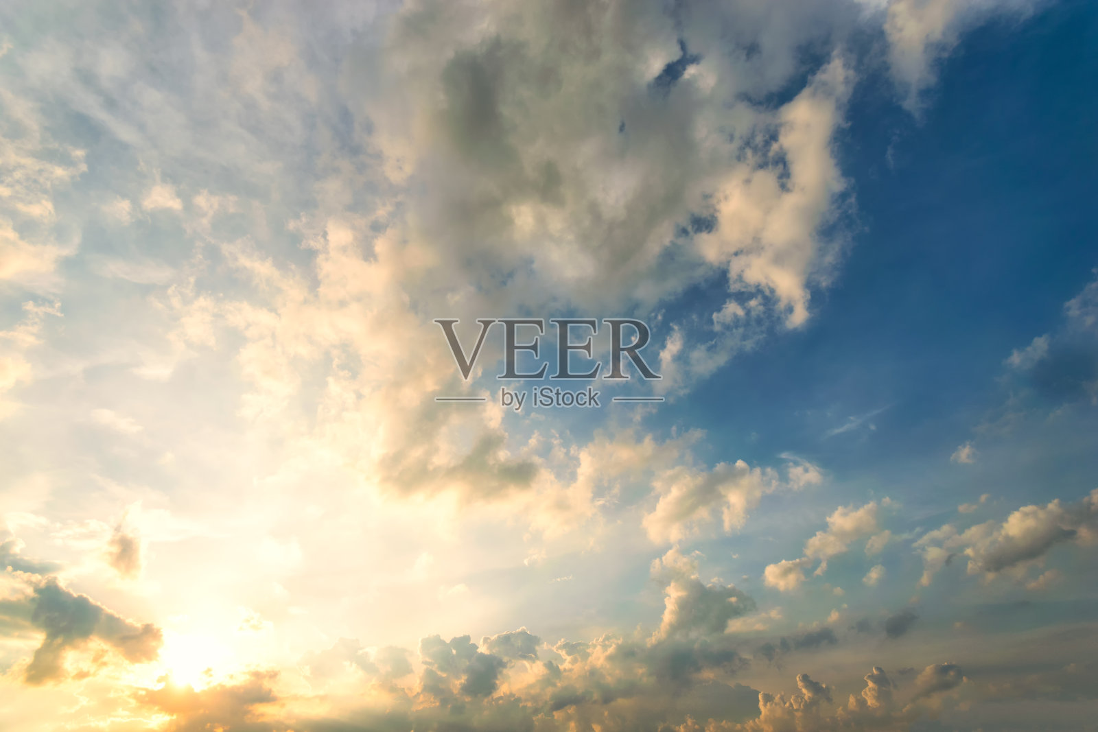 天空中蓝色和橙色的阳光穿过天空中的云朵照片摄影图片