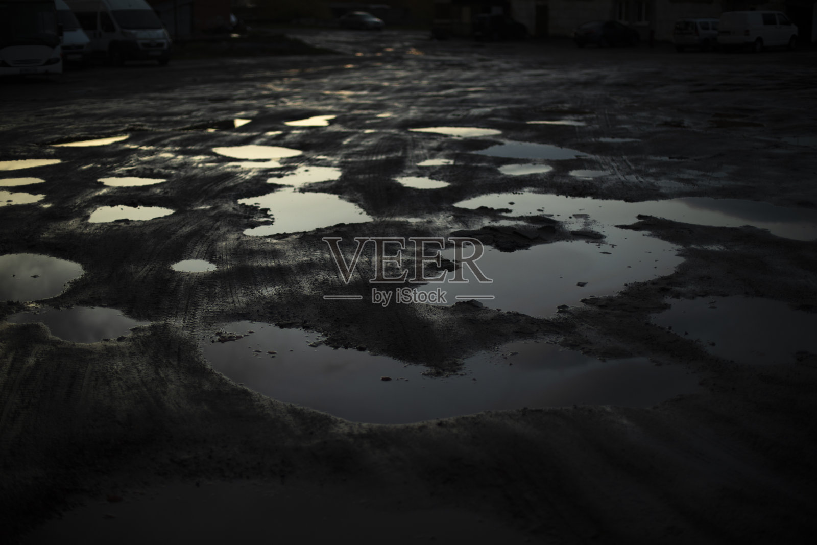 黑暗中的大水坑。水坑里的反光。俄罗斯的道路很糟糕。照片摄影图片