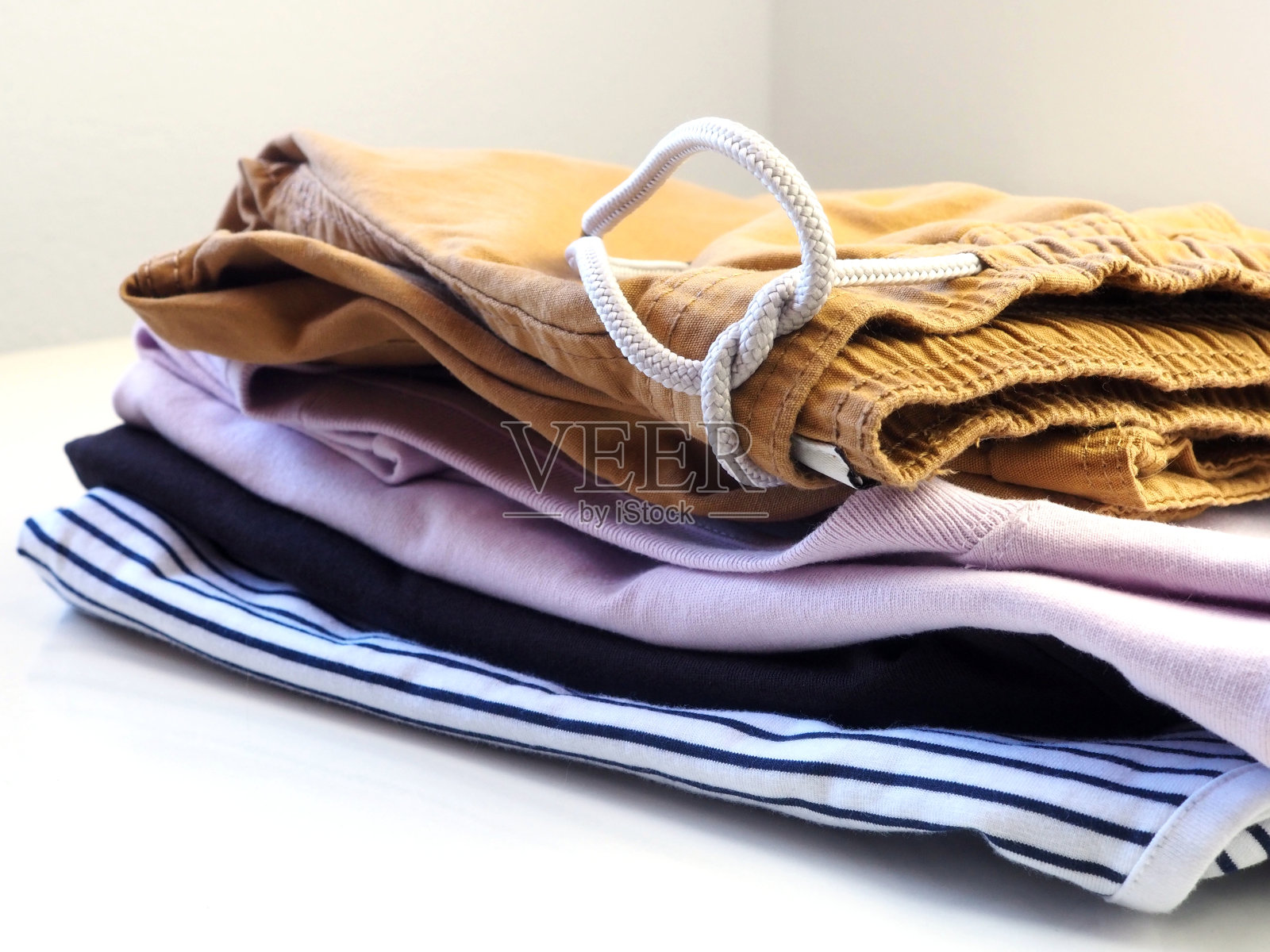 男人的夏天的衣服。一堆无袖t恤和短裤。照片摄影图片