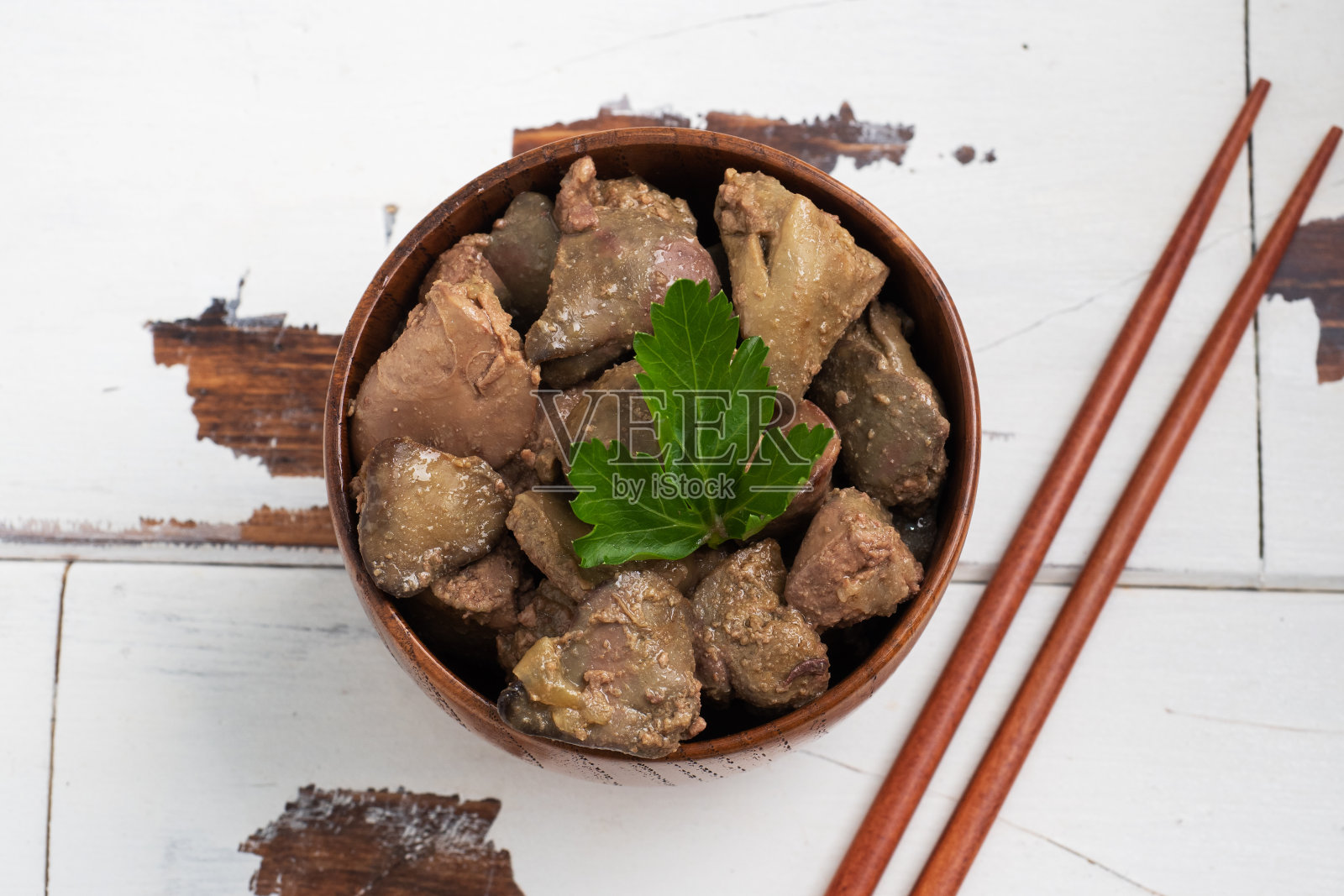 煎或烤鸡肝配洋葱和酱汁，绿欧芹叶装盘。富含铁质的肉菜。照片摄影图片