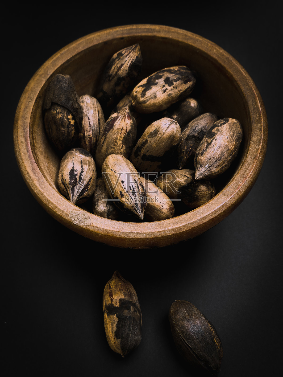 一碗黑底的山核桃照片摄影图片