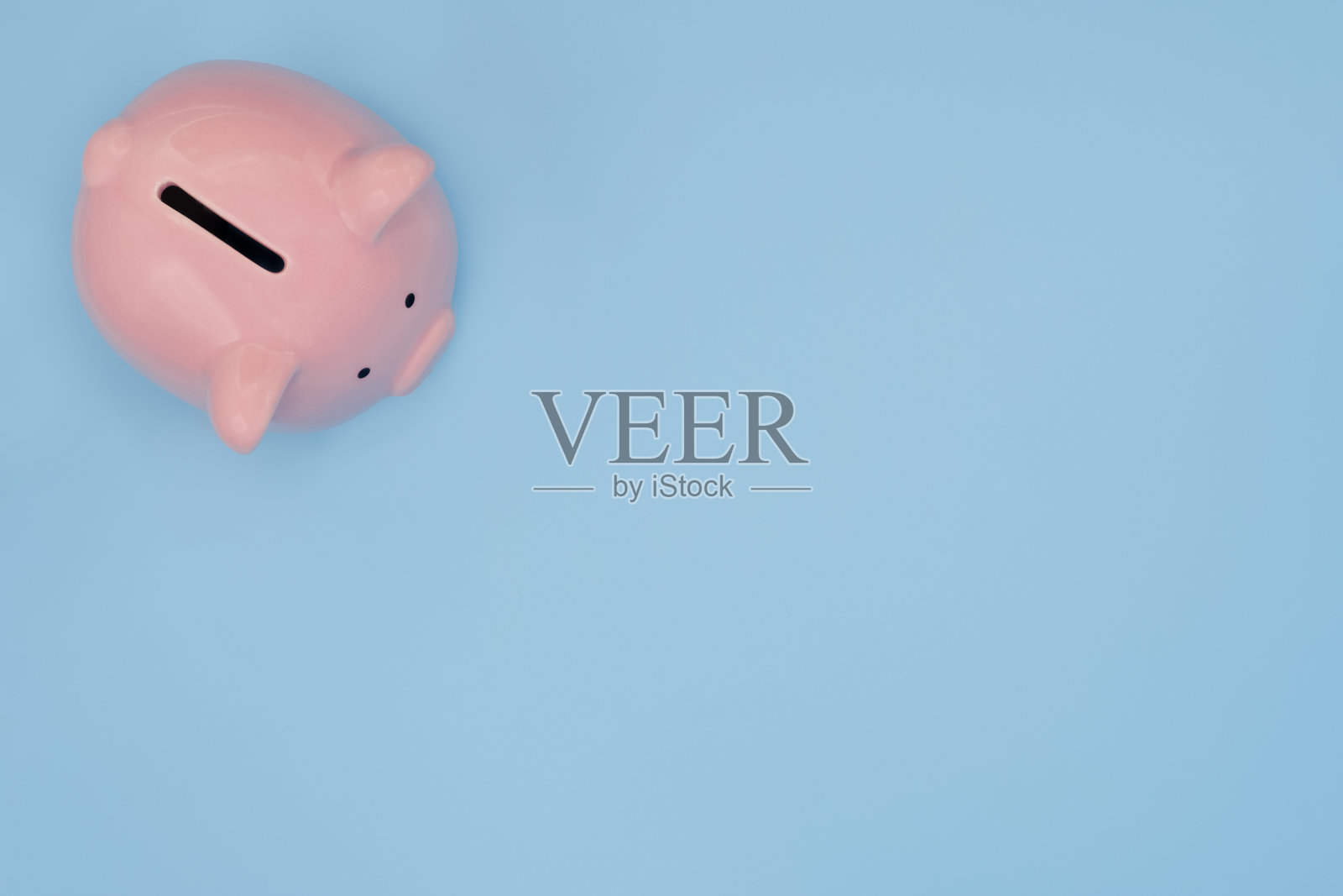 俯视图的粉红色存钱罐孤立在浅蓝色背景与剪切路径。照片摄影图片