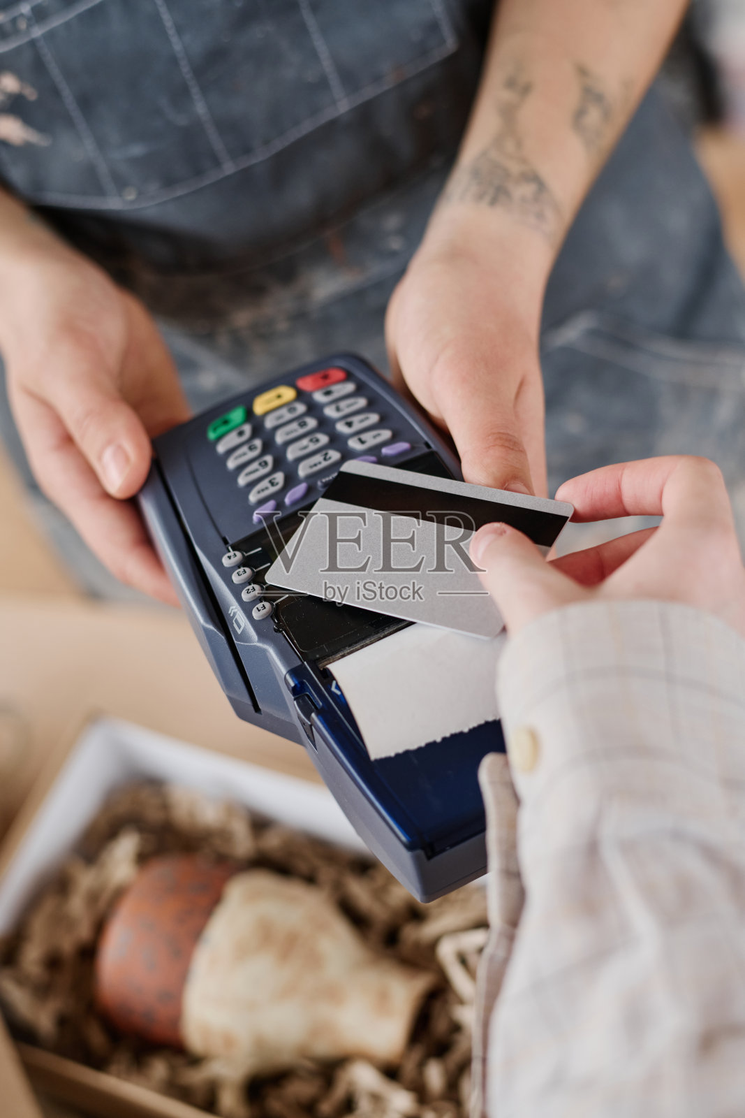 手持支付终端的年轻女店员和客户的手照片摄影图片