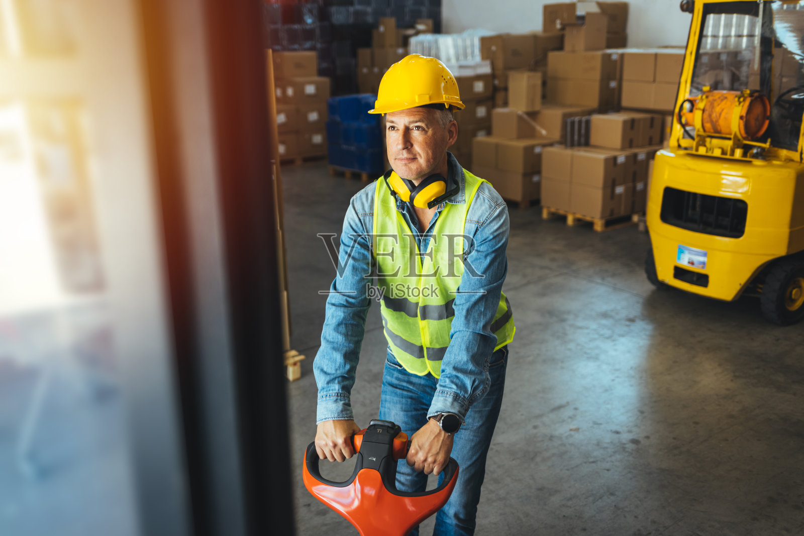 戴安全帽和防护服的人使用托盘千斤顶照片摄影图片