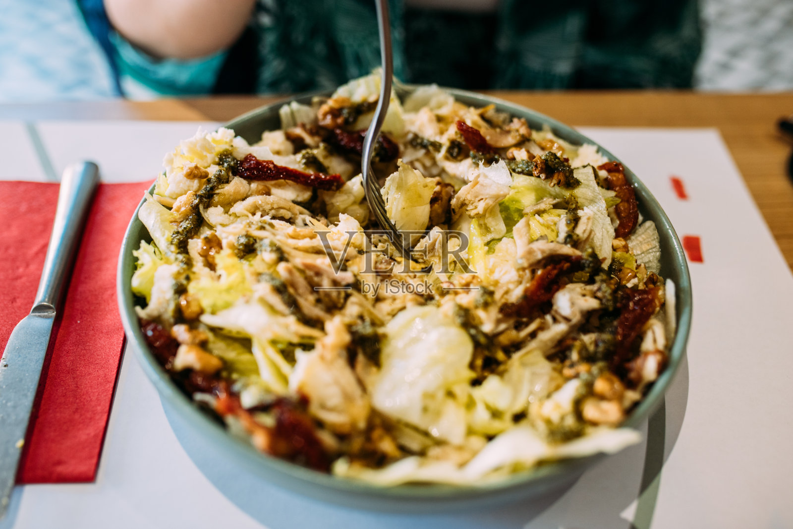 吃鸡肉沙拉的女人干番茄和香蒜沙司照片摄影图片