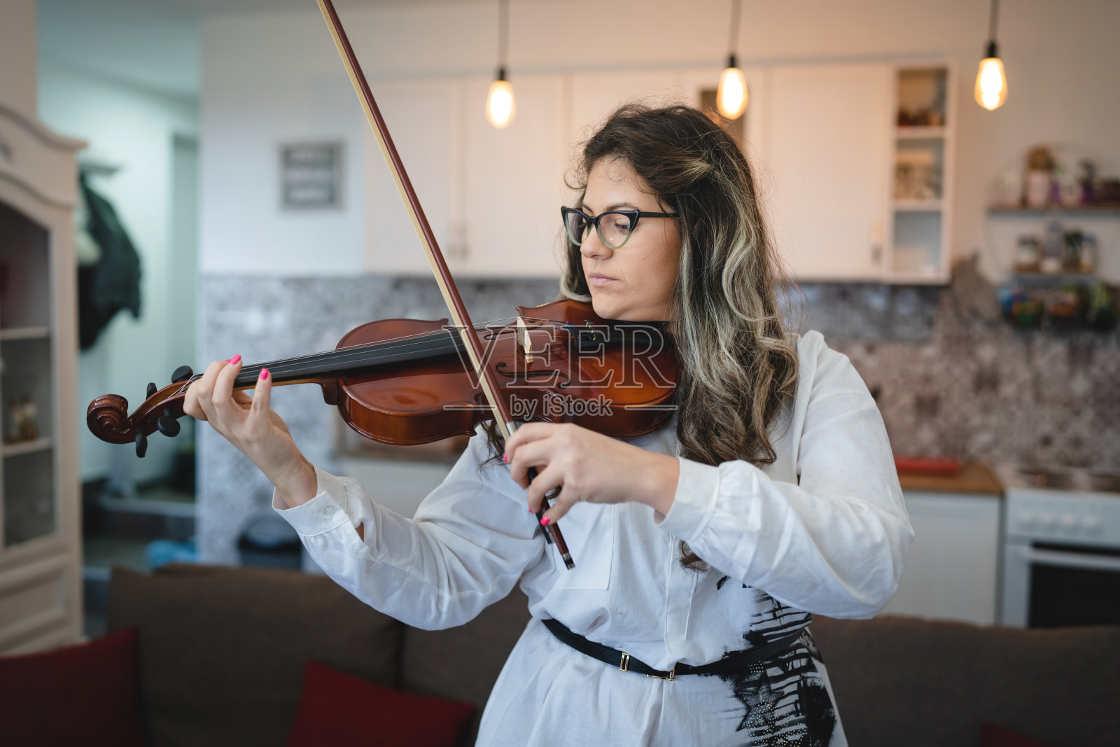一名女性白人在她的房子室内拿着小提琴和学习演奏前视图腰部以上研究从家庭生活方式的概念照片摄影图片