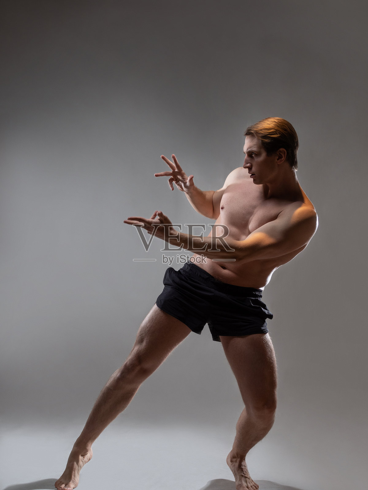 年轻的肌肉男以一种富有表现力的姿势、艺术的姿态出现在英雄面前照片摄影图片