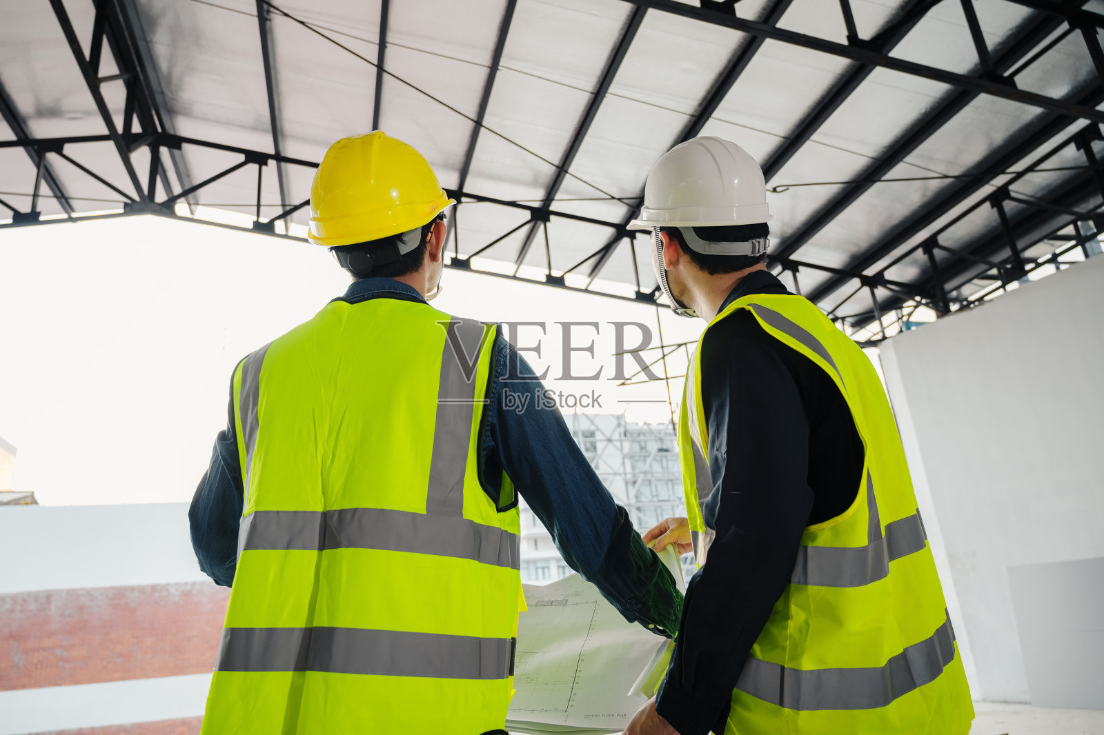 土木工程师和施工主管在施工现场检查建筑物的内部施工。建筑工程师或建筑师和工头检查建筑内部的施工。照片摄影图片