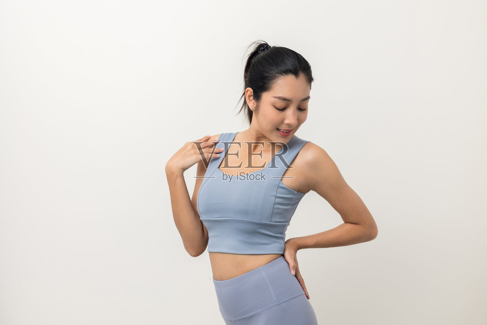 快乐年轻美丽的亚洲女人与运动服上孤立的白色背景。肖像运动的女人站姿锻炼锻炼在工作室。照片摄影图片