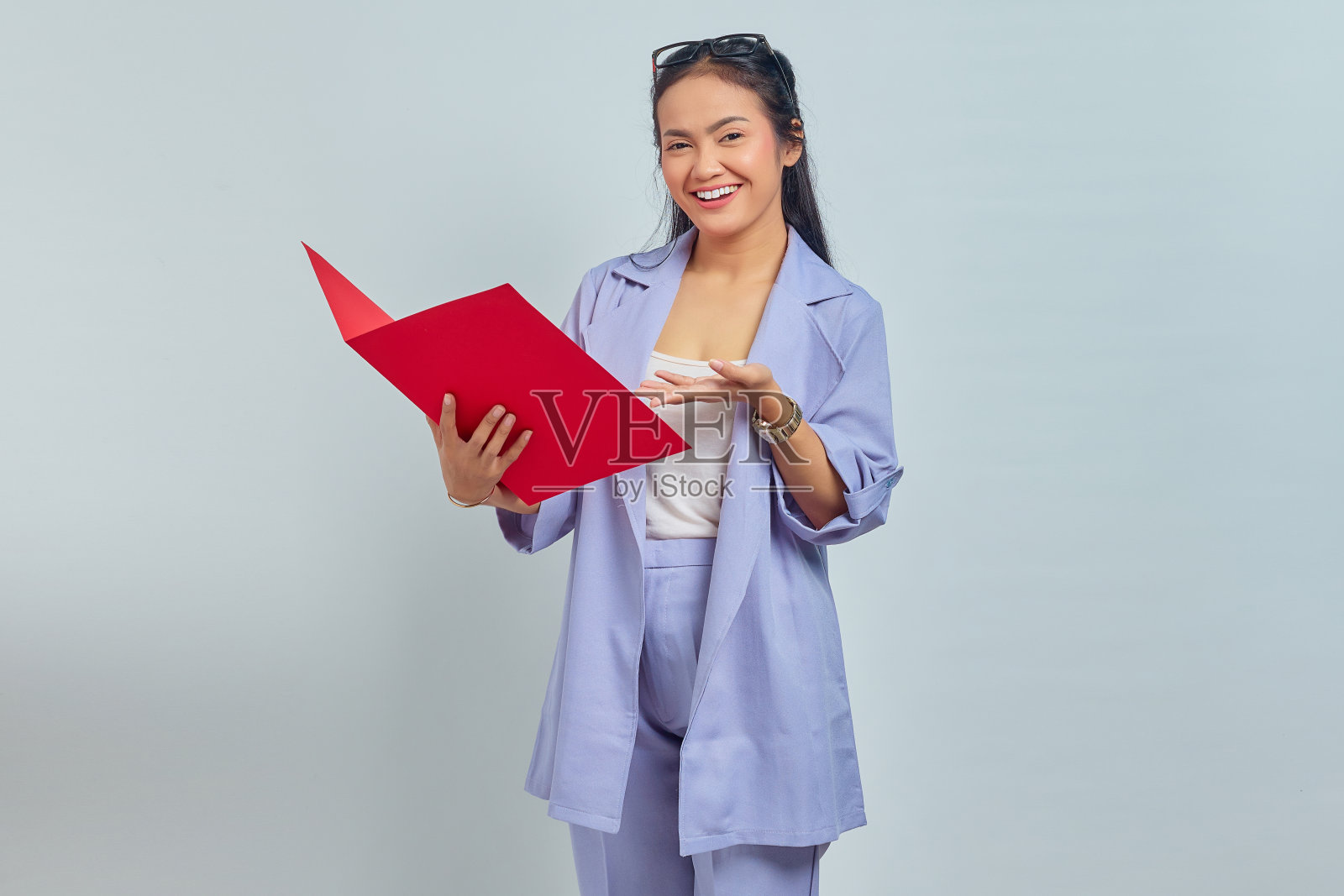 肖像开朗的年轻亚洲商业女性西装站在指着文件文件夹的手掌孤立在紫色的背景照片摄影图片