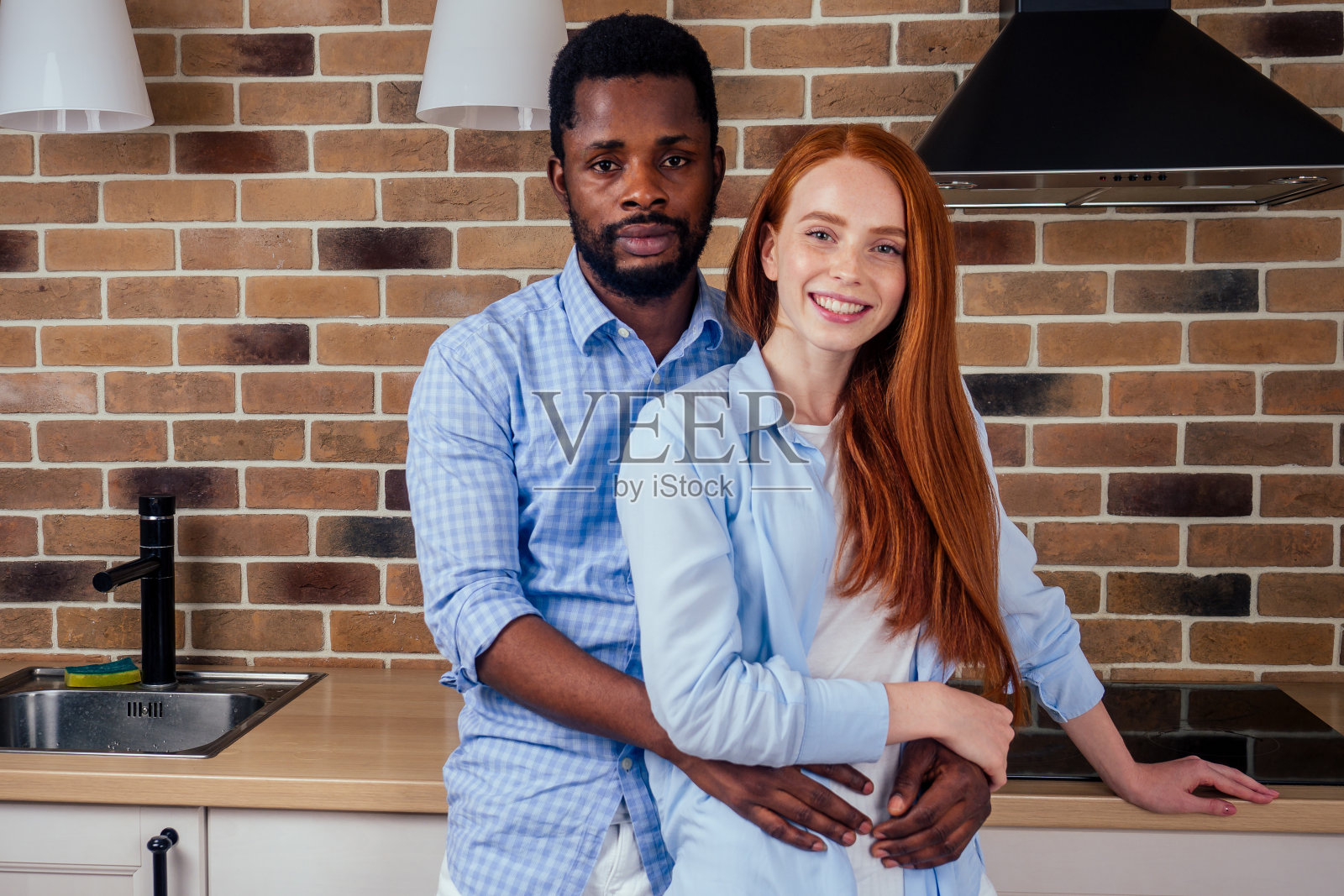 白种红发女性和非洲裔男性正在家里吃早餐照片摄影图片