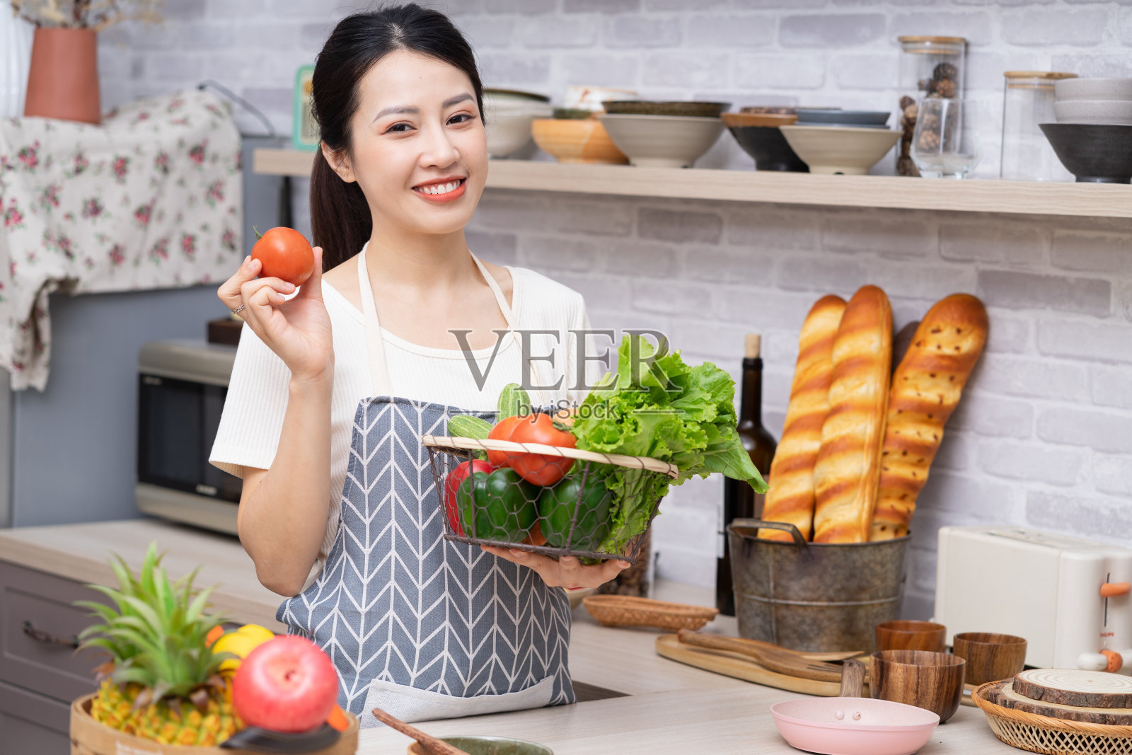 年轻的亚洲妇女准备在厨房做饭照片摄影图片