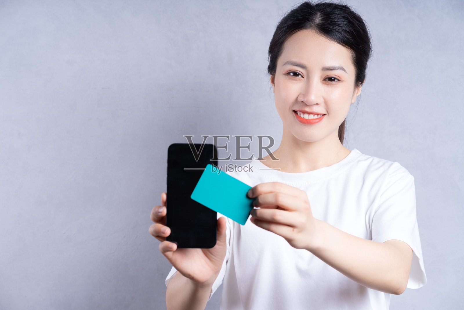 背景是年轻的亚洲女性手持银行卡的图像照片摄影图片