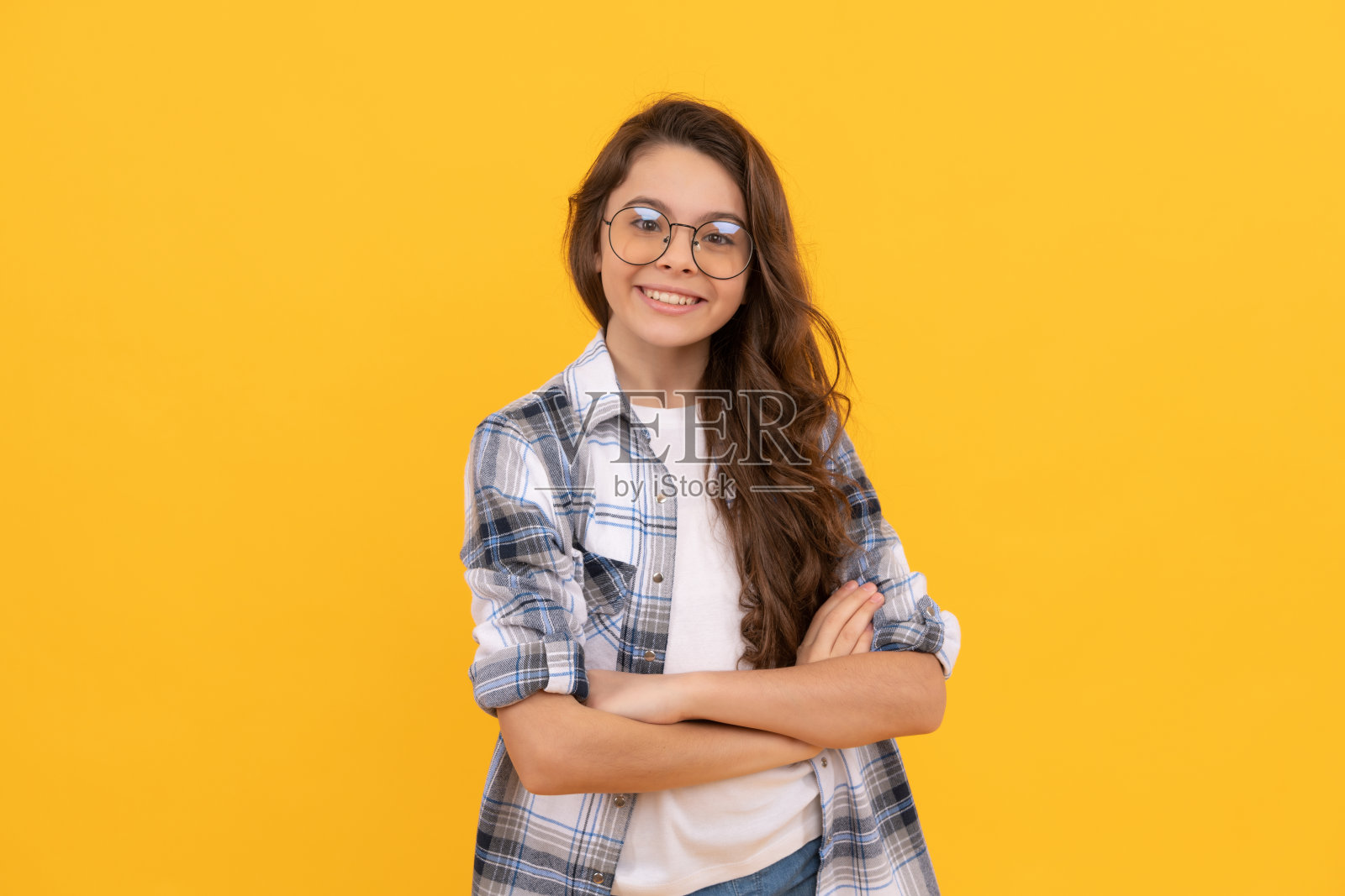穿着格子衬衫和戴眼镜的快乐少年在黄色背景前照片摄影图片
