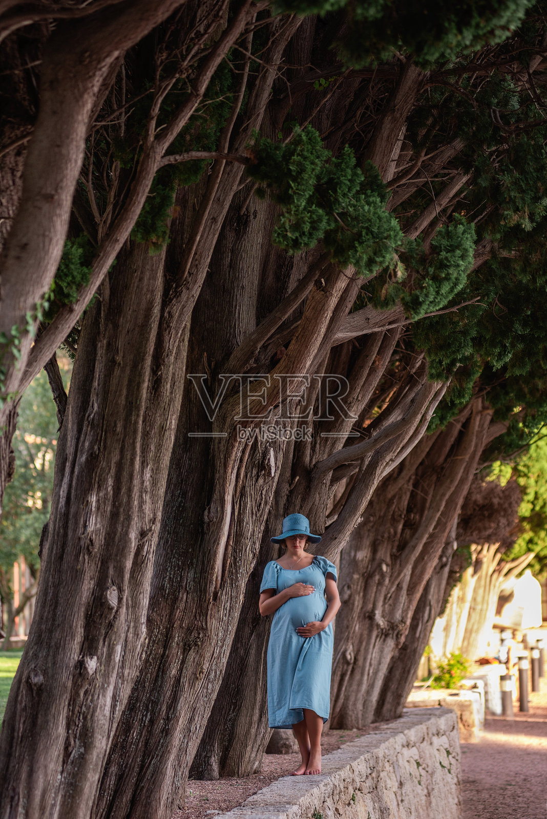 中年孕妇肖像，穿着牛仔蓝裙，戴着帽子。旅行怀孕。孕妇的概念照片摄影图片