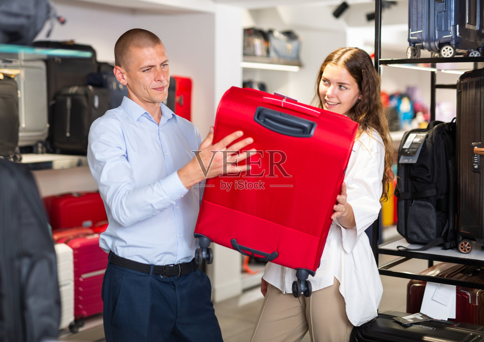 男人和女人在商店买手提箱照片摄影图片