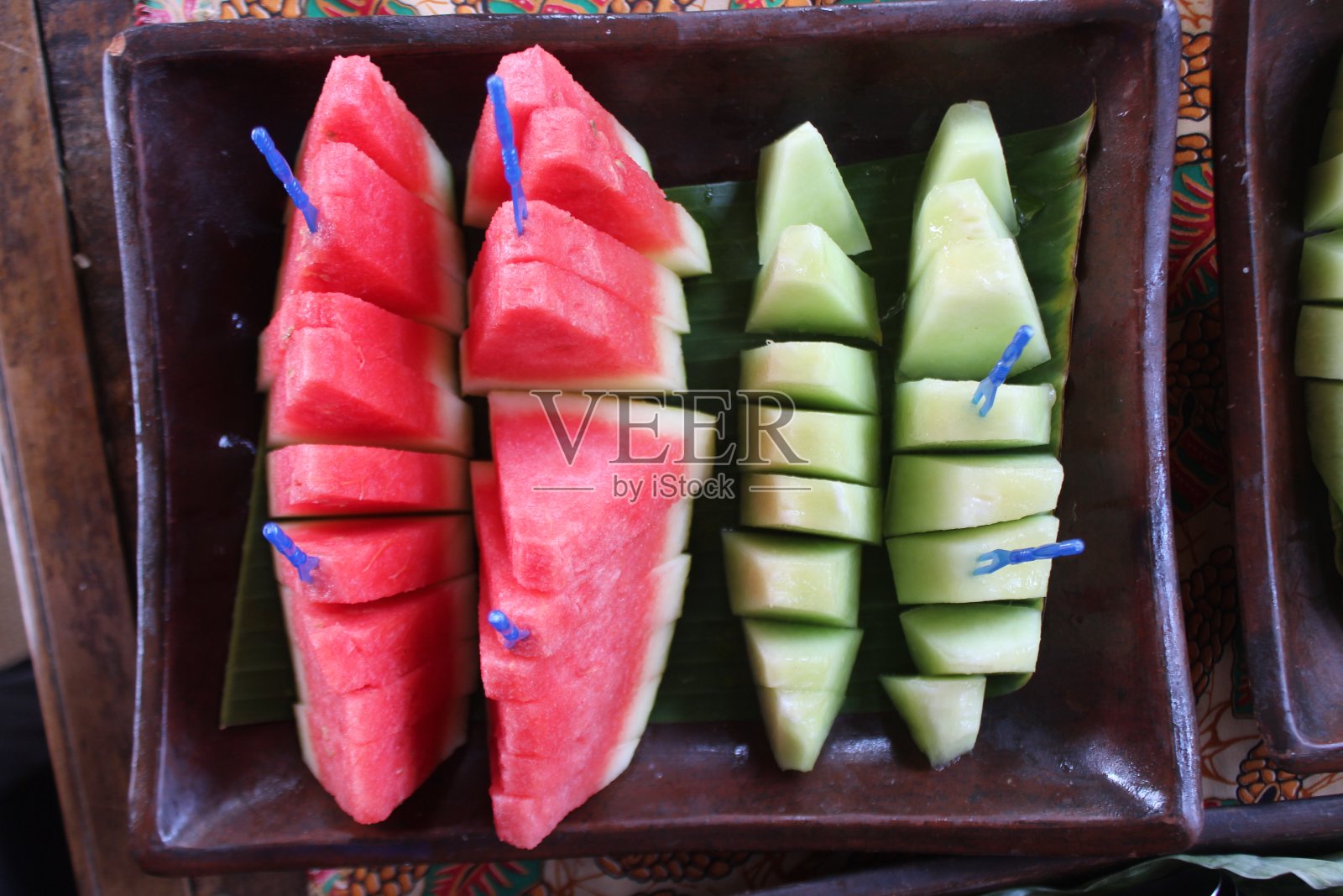 新鲜的沙拉水果放在香蕉叶上。由西瓜和菠萝片做成的沙拉照片摄影图片