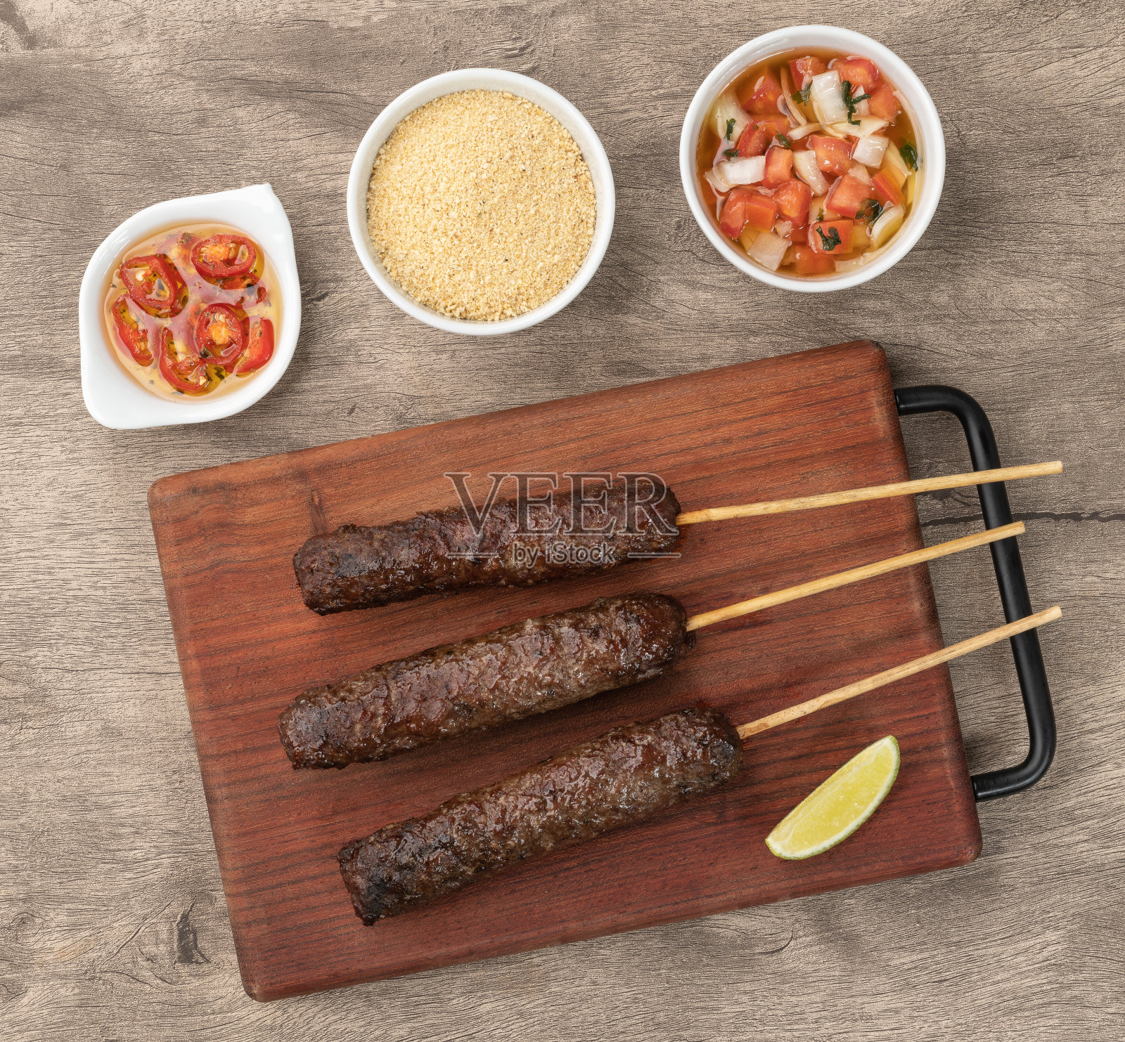 肉卡夫塔串在木板上与法罗法和油醋汁照片摄影图片