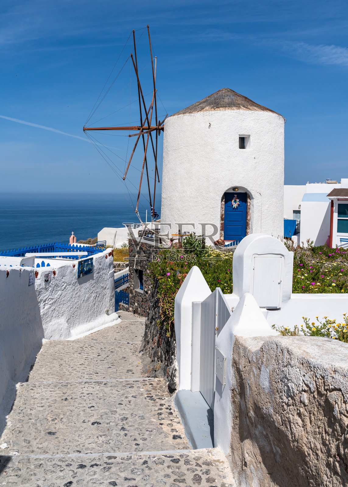 希腊圣托里尼岛，俯瞰爱琴海的伊亚岛标志性的白色风车照片摄影图片