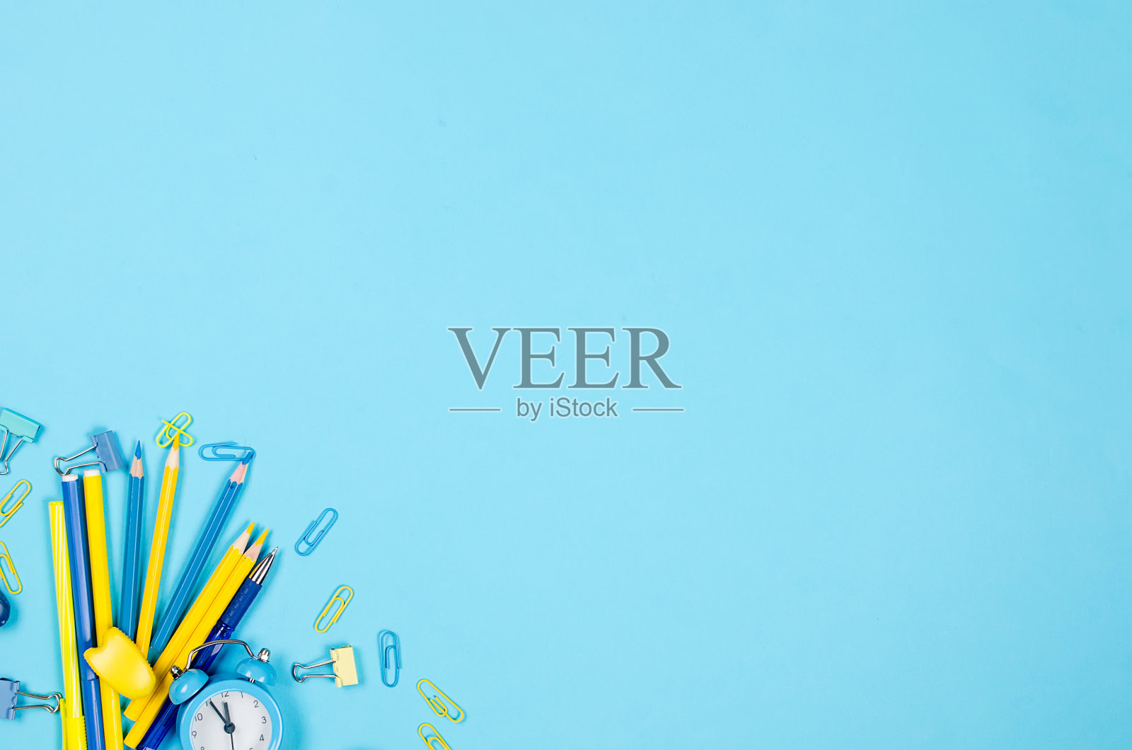 蓝色背景的蓝色和黄色学校文具。照片摄影图片