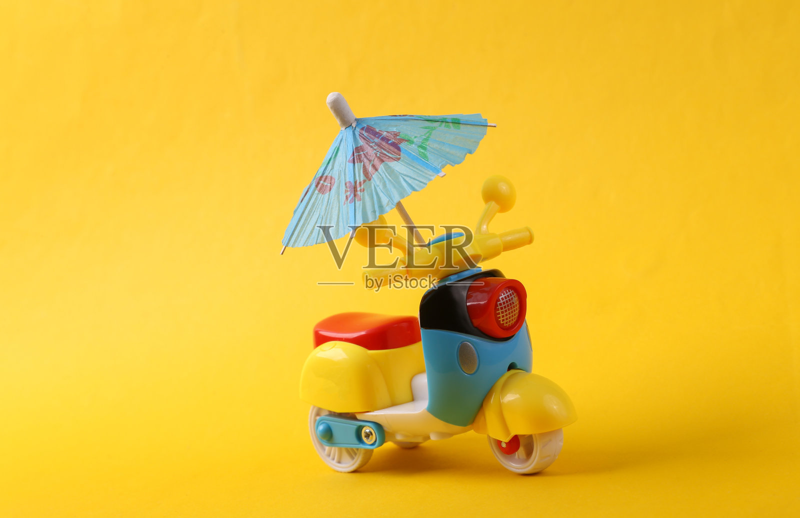 黄色背景的玩具滑板车和伞的特写照片摄影图片