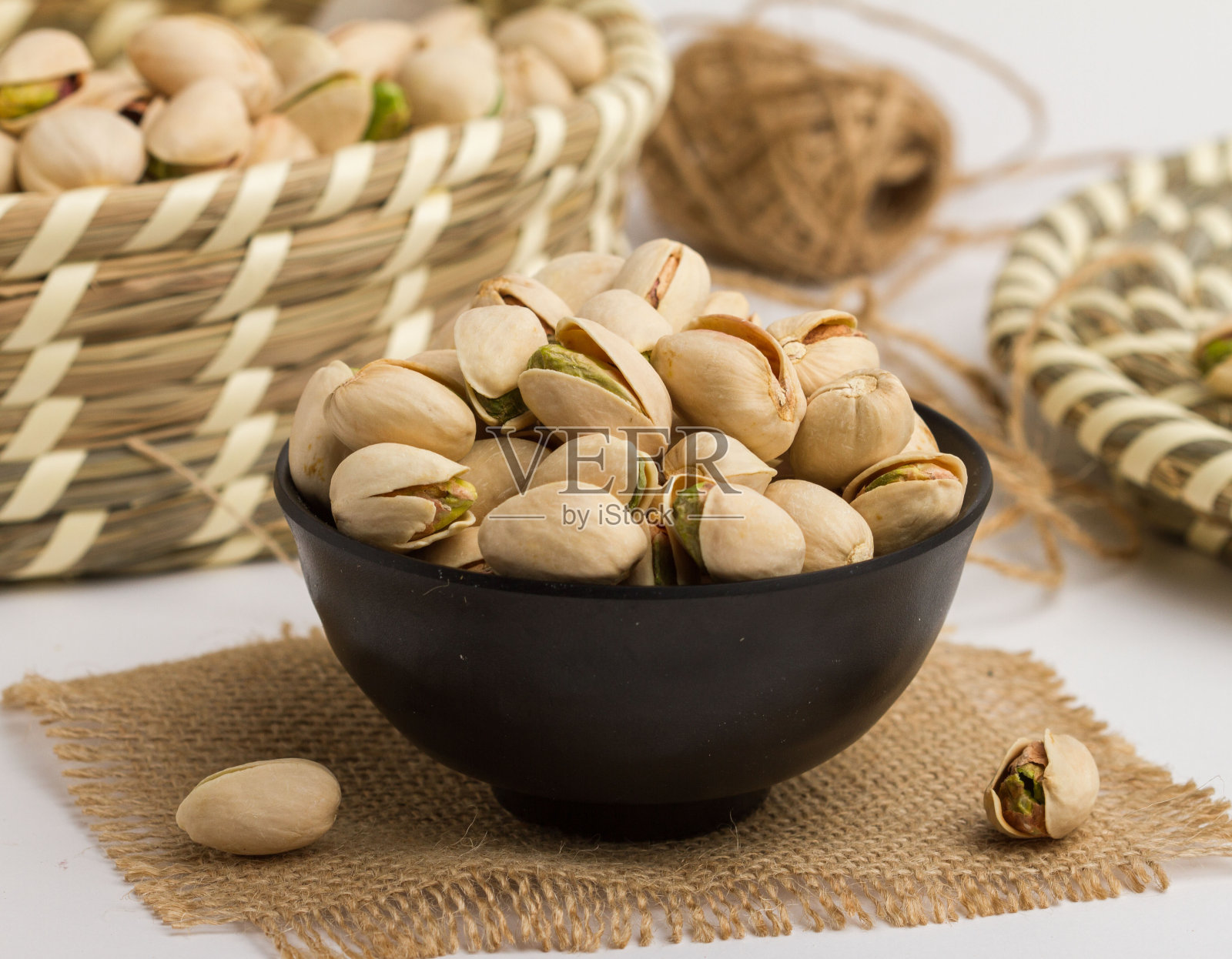 新鲜的开心果在一个碗孤立在餐巾的侧视图坚果在灰色的背景照片摄影图片