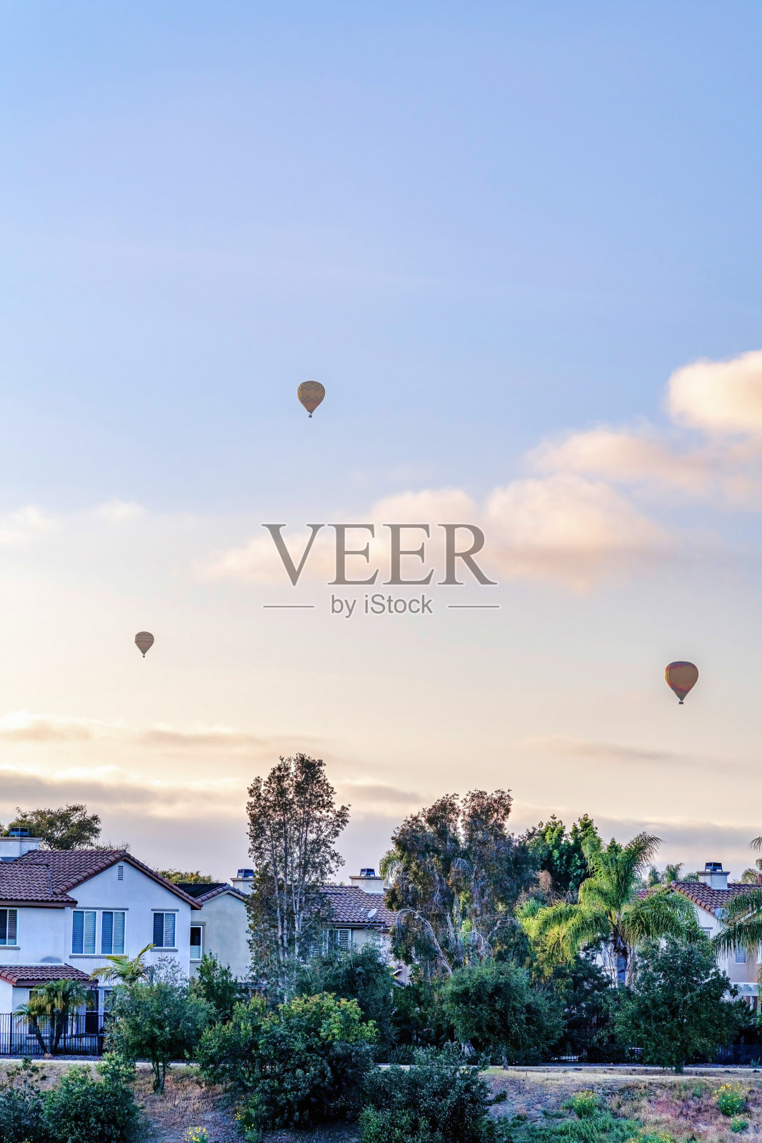 加利福尼亚州圣地亚哥，热气球在多云的蓝天下飞过房屋照片摄影图片