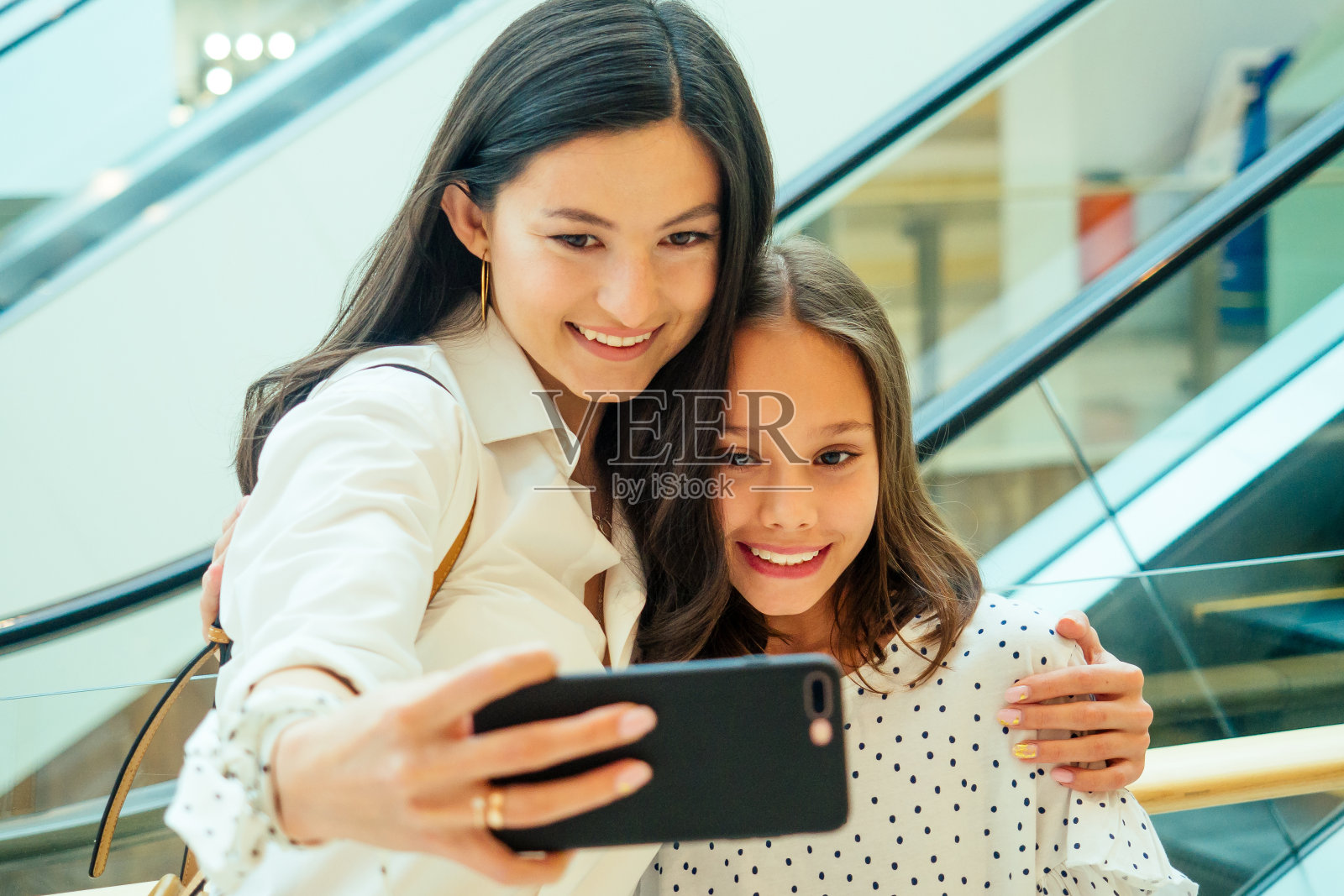 阿拉伯母女在购物后用手机拍照或视频聊天照片摄影图片