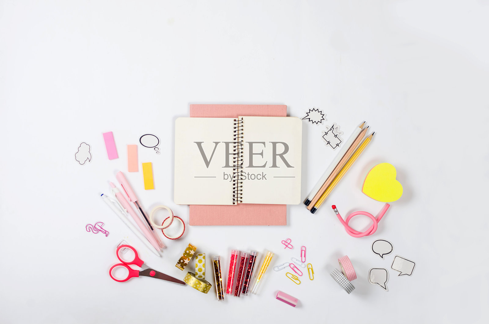 平铺构图，白色背景上是粉红色的学校用品。照片摄影图片