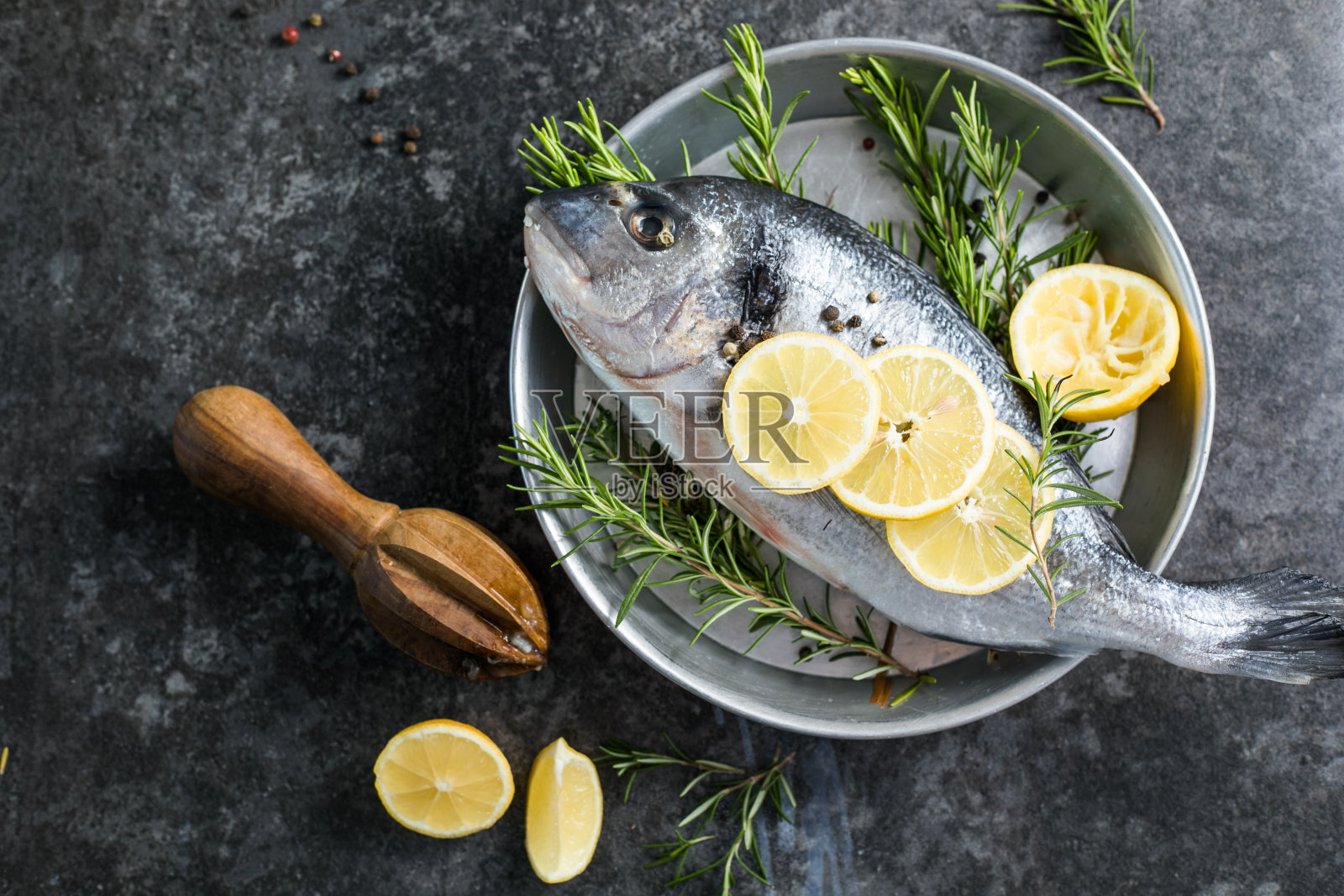 加香料的生多拉多鱼。多拉多和烹饪食材放在桌子上照片摄影图片