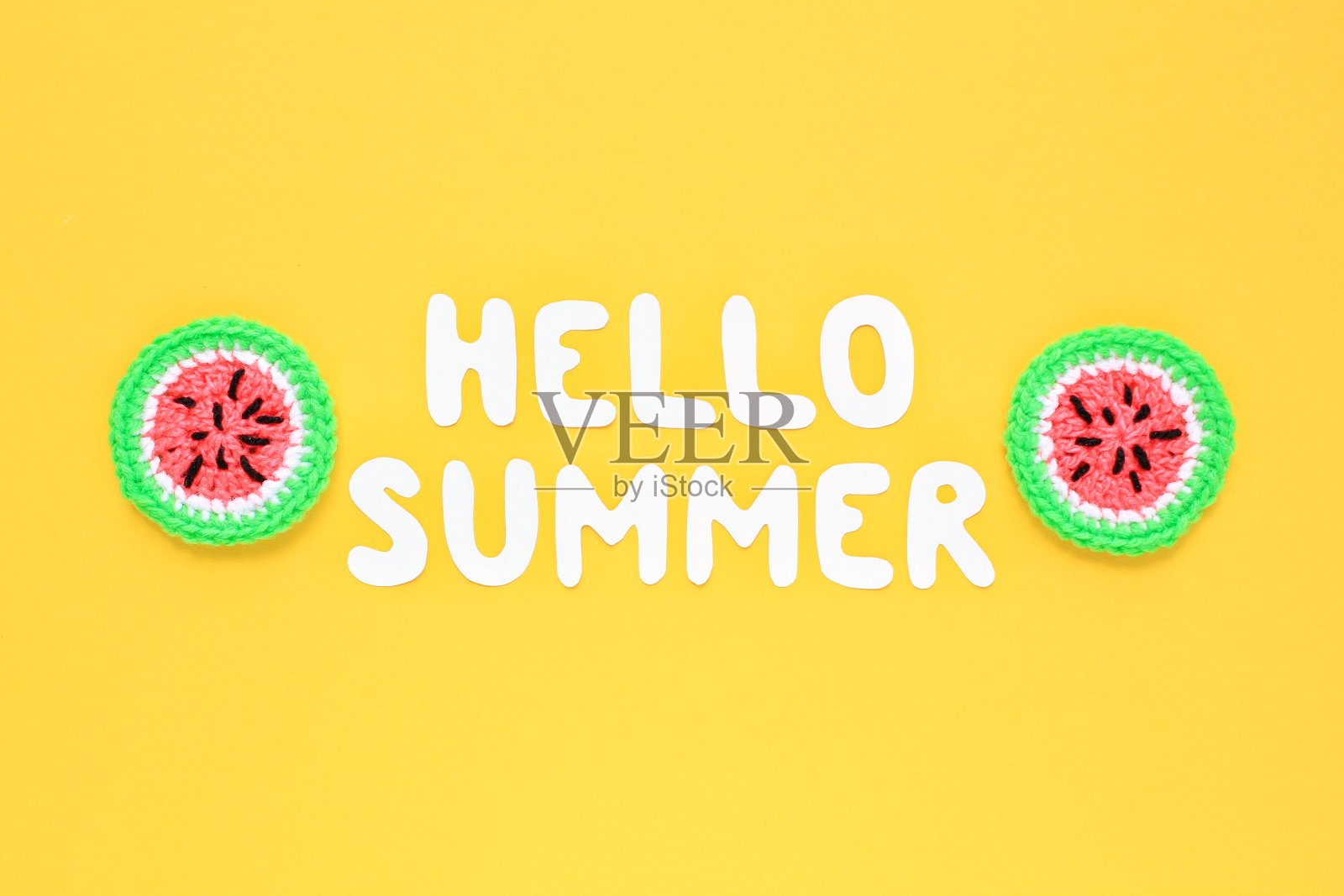彩色钩针手工制作的西瓜片和字母你好夏天在黄色的背景照片摄影图片