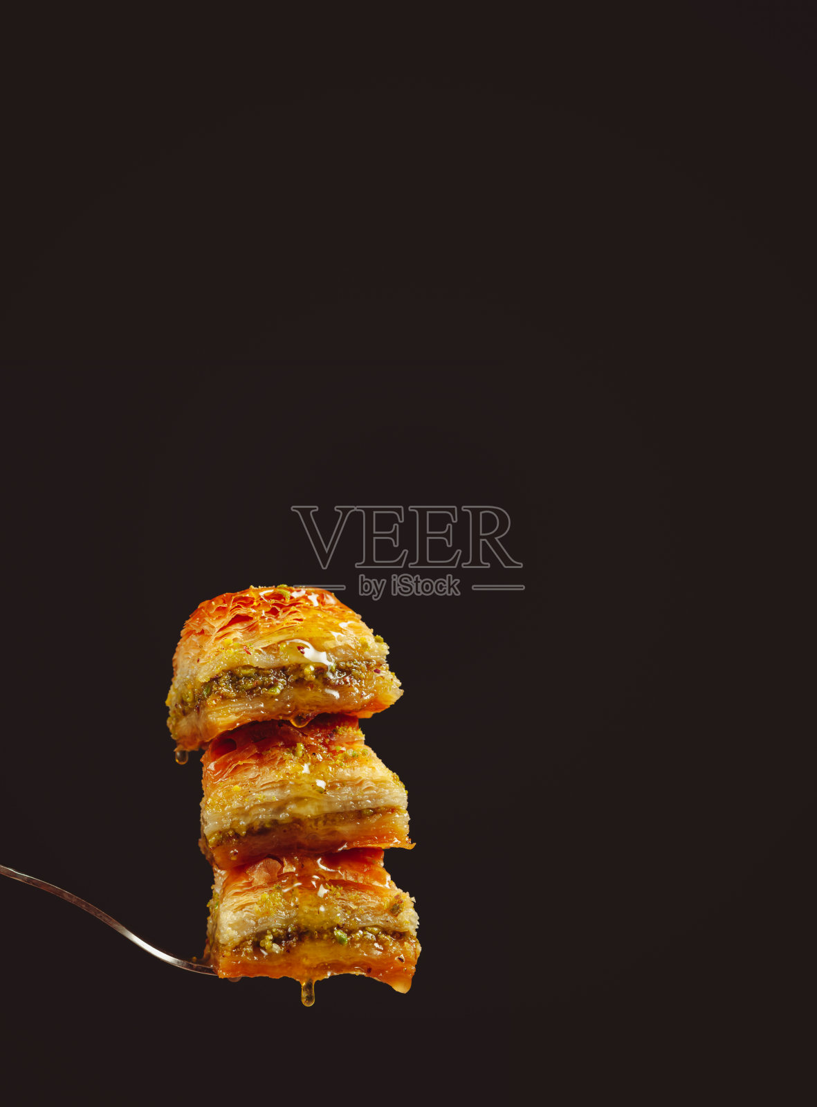 黑色背景上的开心果果仁蜜饼甜点。照片摄影图片