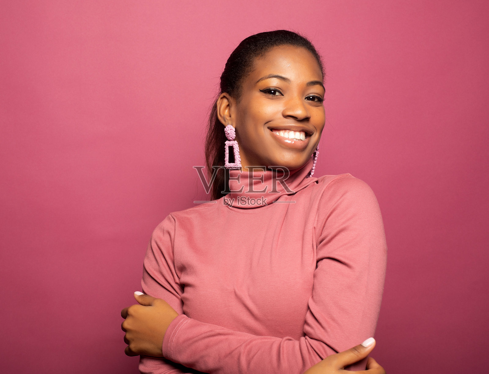 年轻美丽微笑的肖像黝黑皮肤的女人孤立在粉红色的背景。照片摄影图片