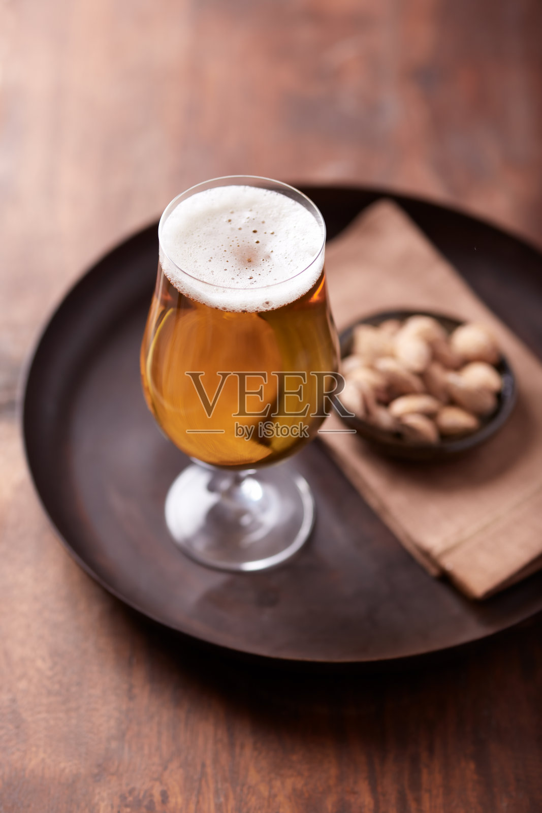 木制背景上的一杯啤酒。副本的空间。照片摄影图片