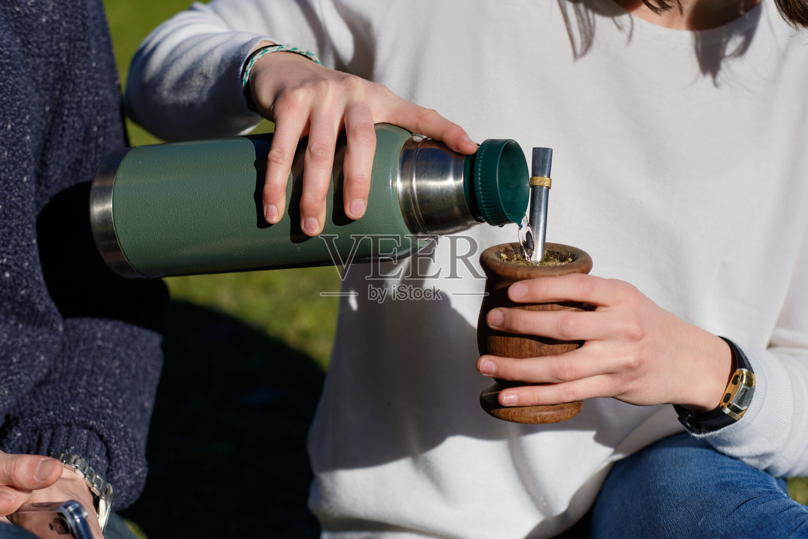 女人的手和伴侣一起拿着南瓜:传统的南美饮料照片摄影图片