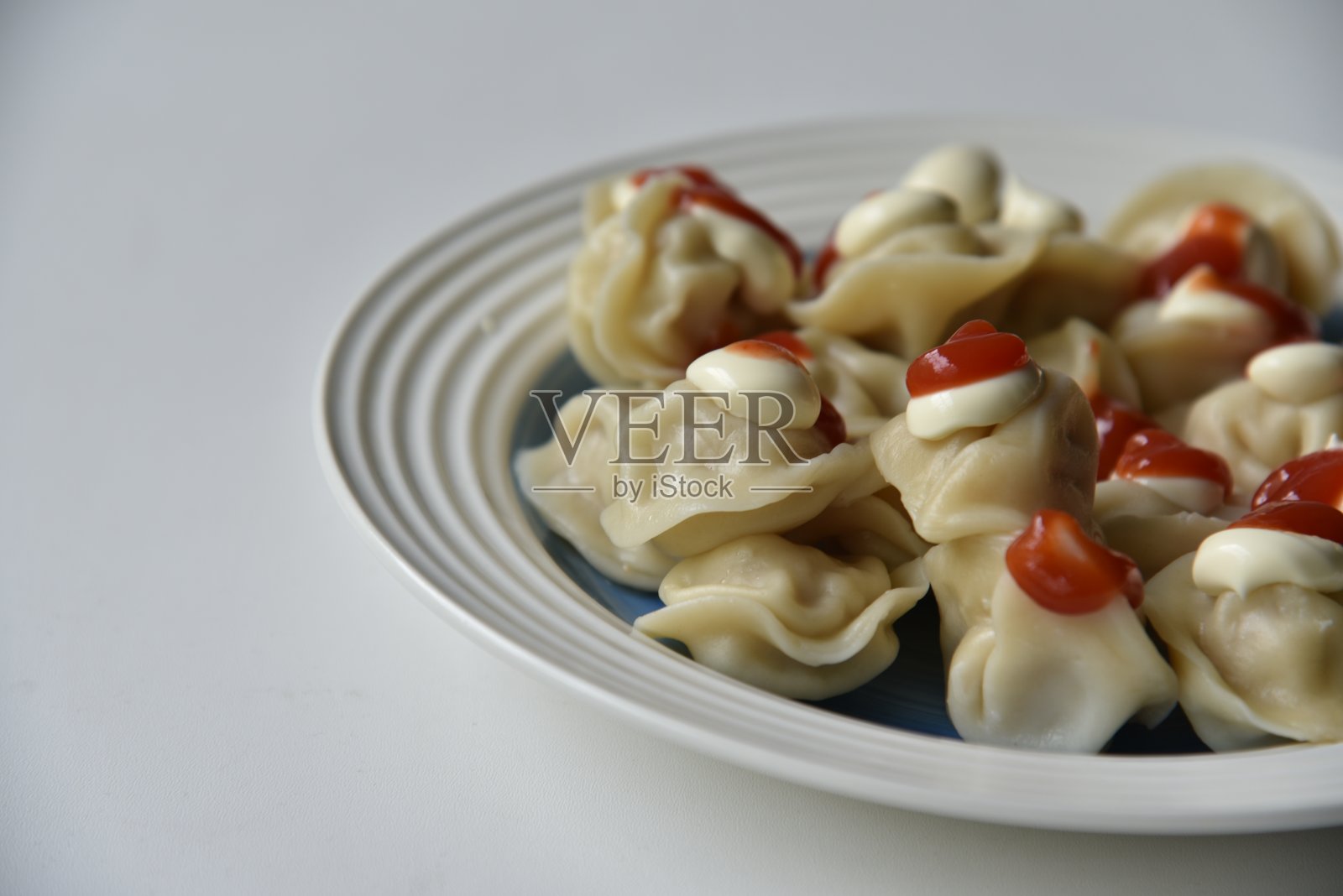 用番茄酱和蛋黄酱在盘子里煮饺子照片摄影图片