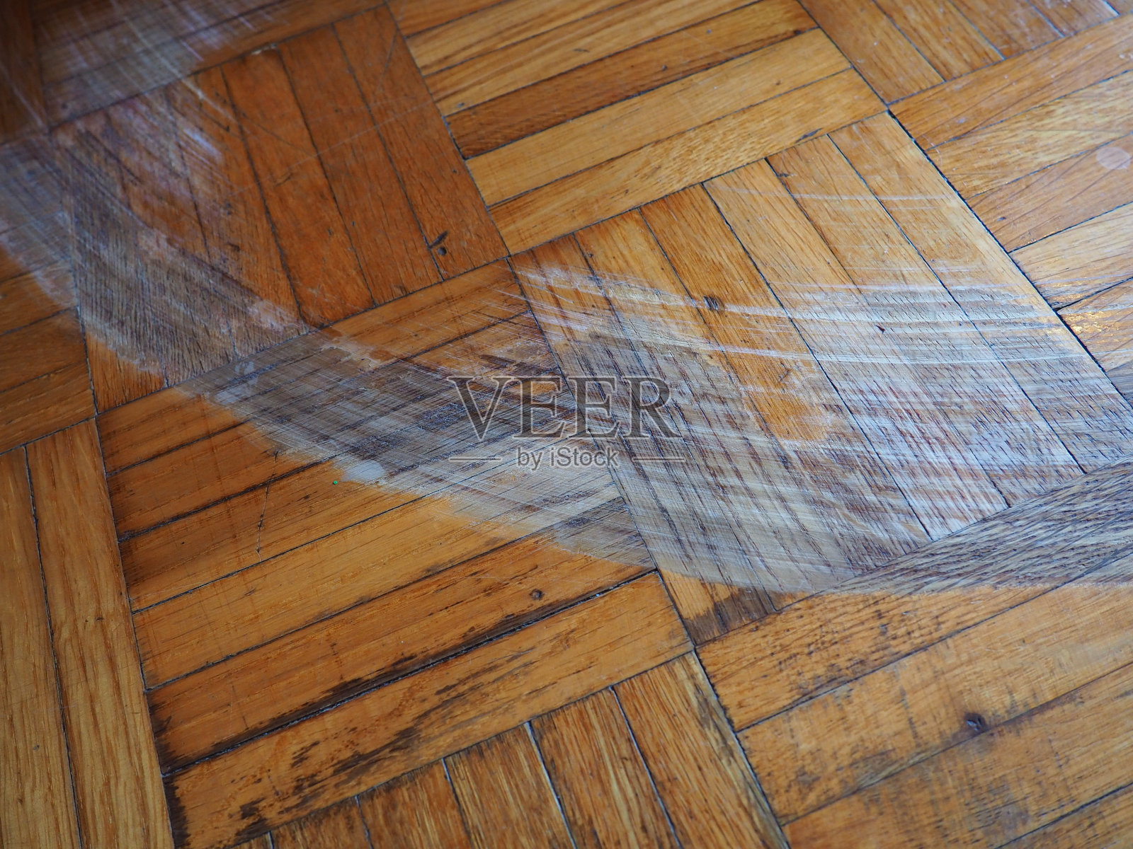 房间的镶木地板有划痕。地板上有划痕，碎屑和凹痕。镶木地板需要修理。照片摄影图片