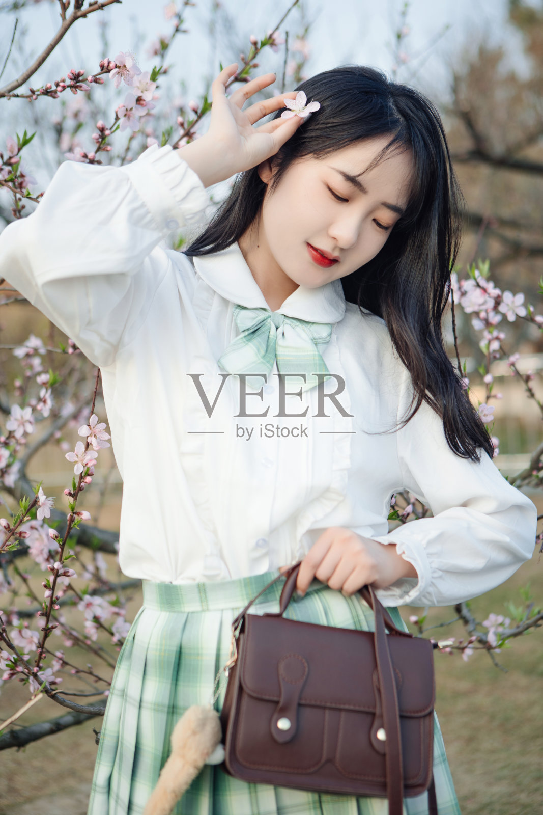 美丽的女孩在公园里欣赏鲜花照片摄影图片