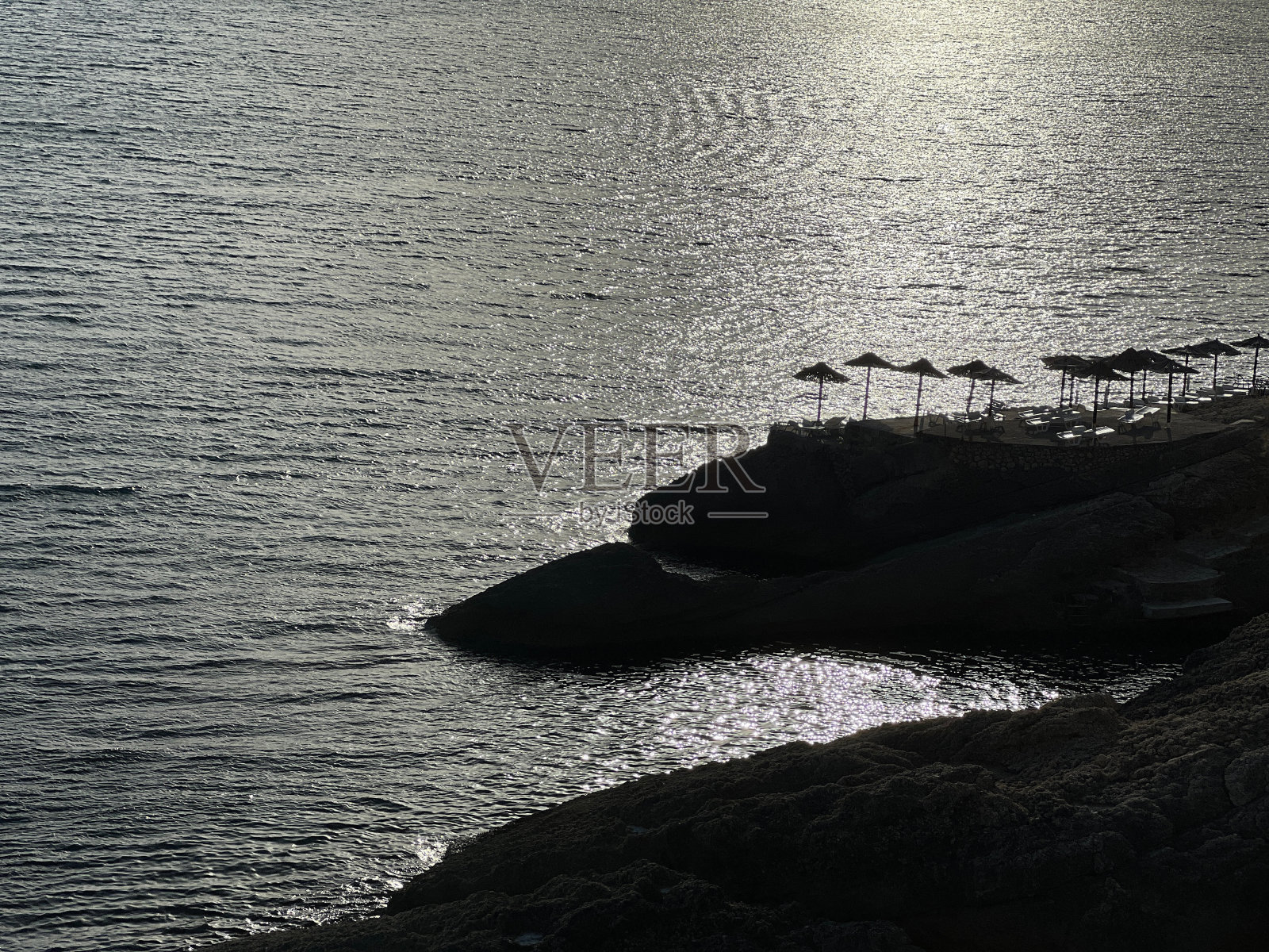 美丽的大海，银色的水在夏夜闪闪发光。照片摄影图片