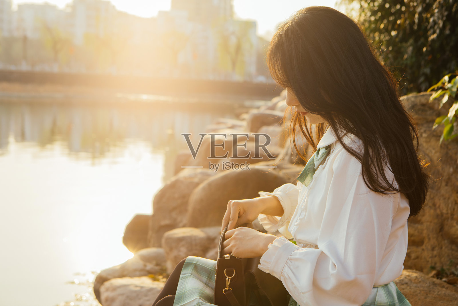 美丽的大学生在夕阳湖畔照片摄影图片