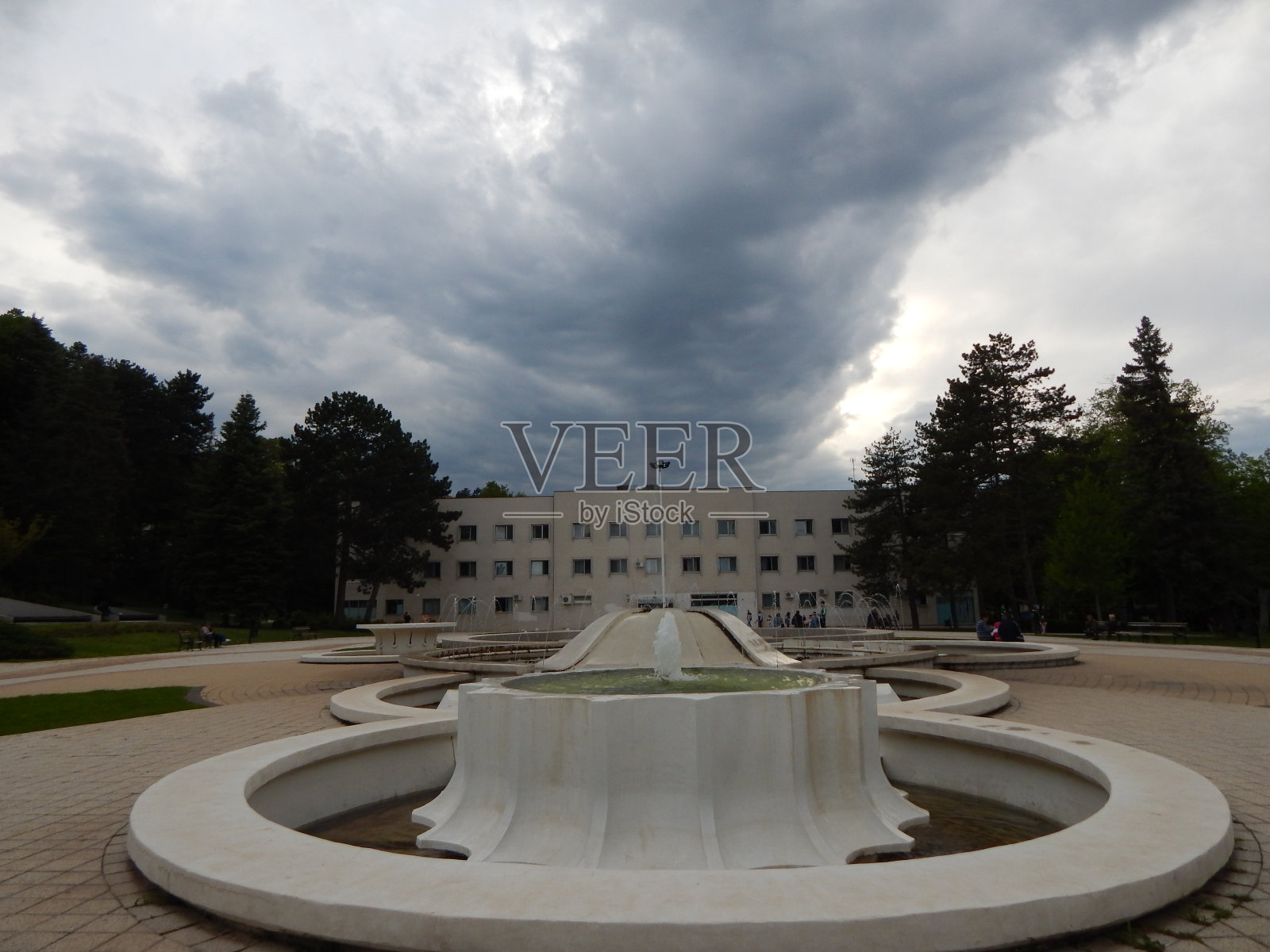 公园里的喷泉朝着阴沉的天空照片摄影图片