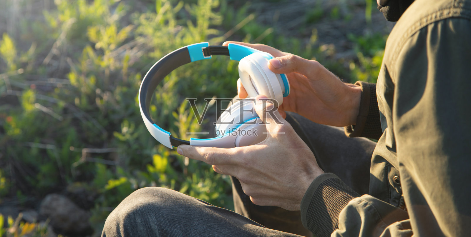 白人男子在户外戴耳机。照片摄影图片