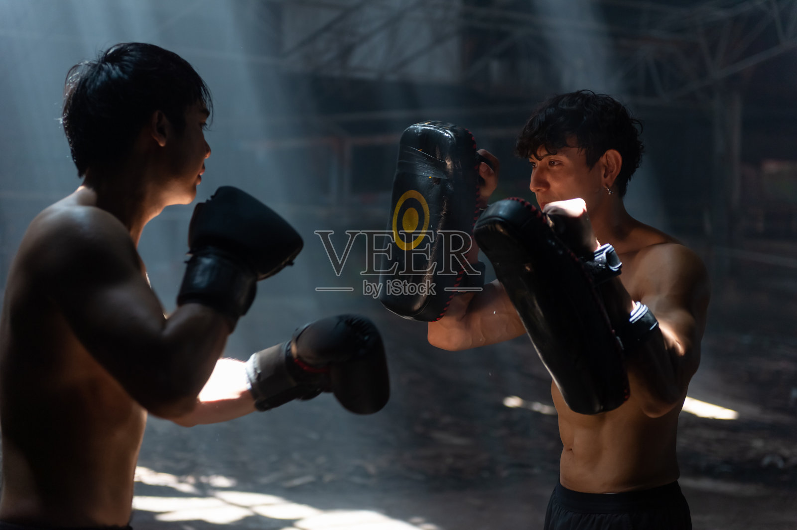 亚洲男子拳击手做练习拳击与男教练在废弃的建筑。照片摄影图片