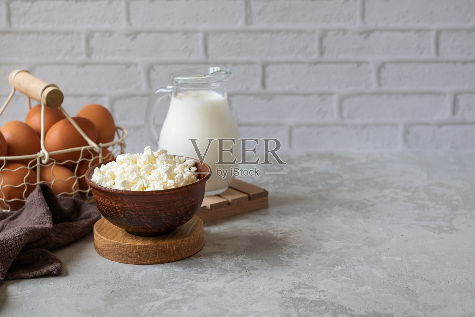 奶制品。凝乳奶酪，一壶牛奶，鸡蛋。照片摄影图片
