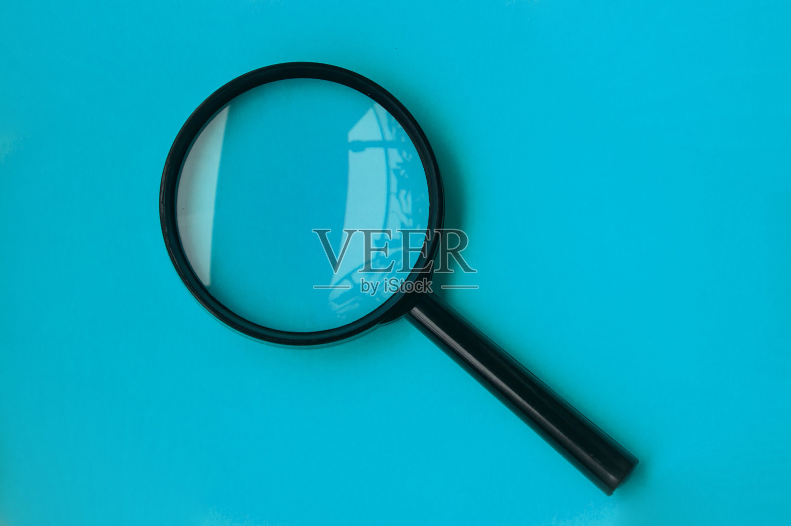 蓝色封面背景上的空白放大镜。照片摄影图片