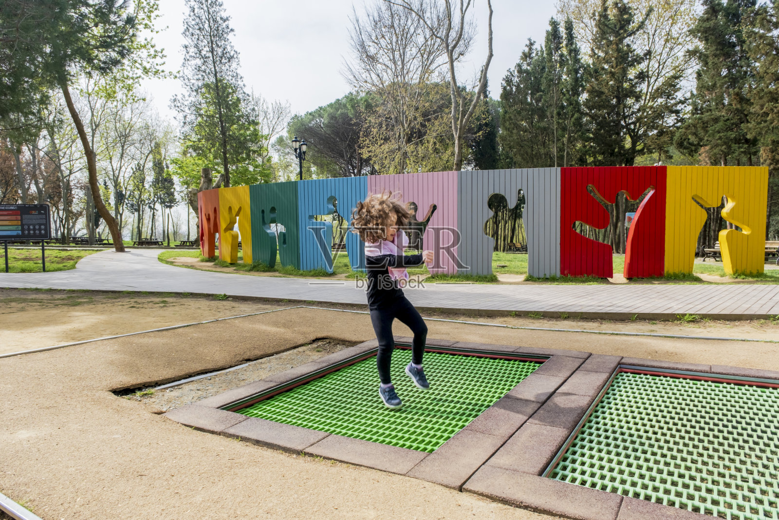 小女孩在操场上玩跳跃玩具照片摄影图片
